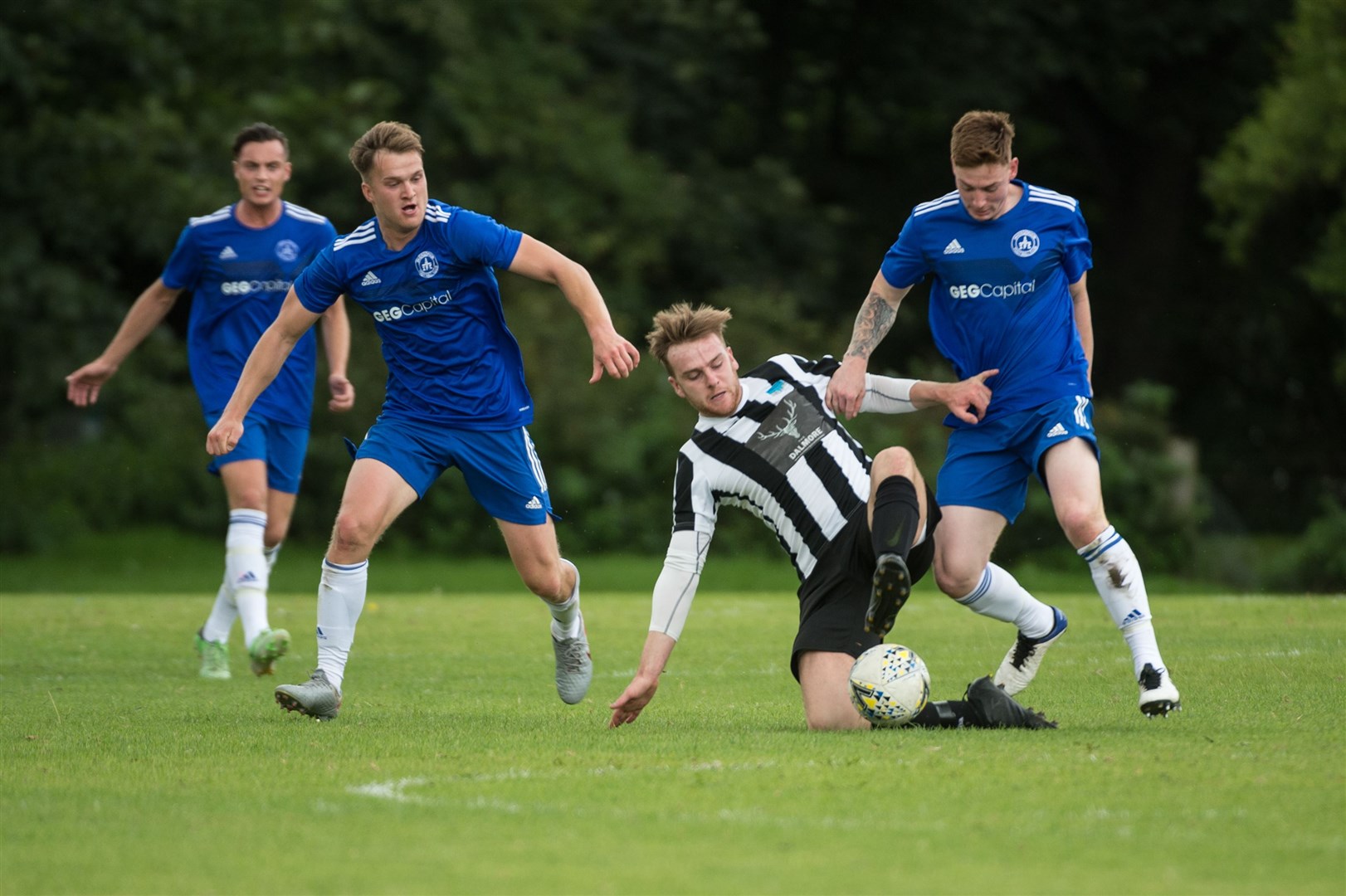Alness midfielder Taylor Sutherland does well to retain possession under pressure. Picture: Callum Mackay