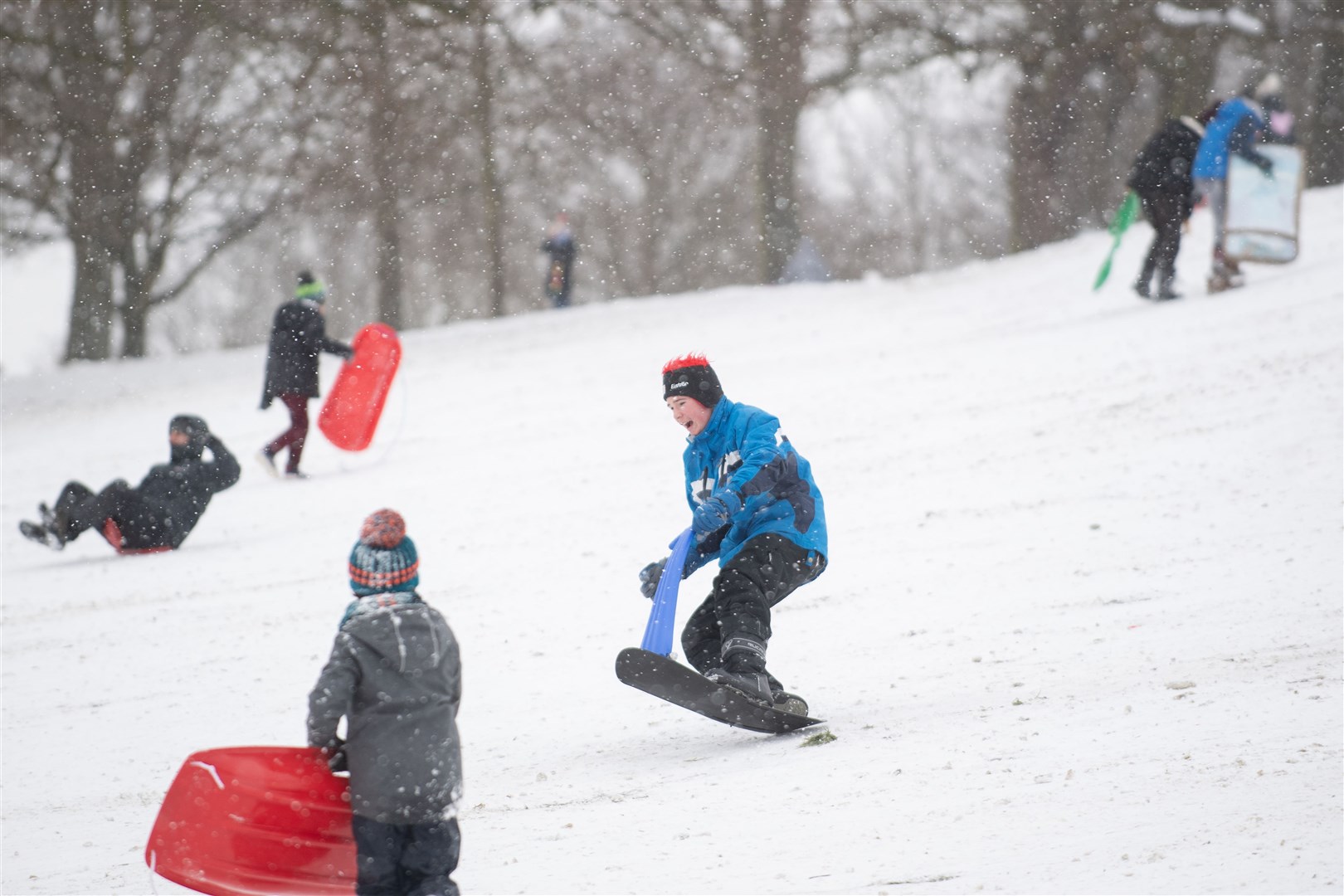 People enjoy the snow at Christchurch Park in Ipswich (Joe Giddens/PA)