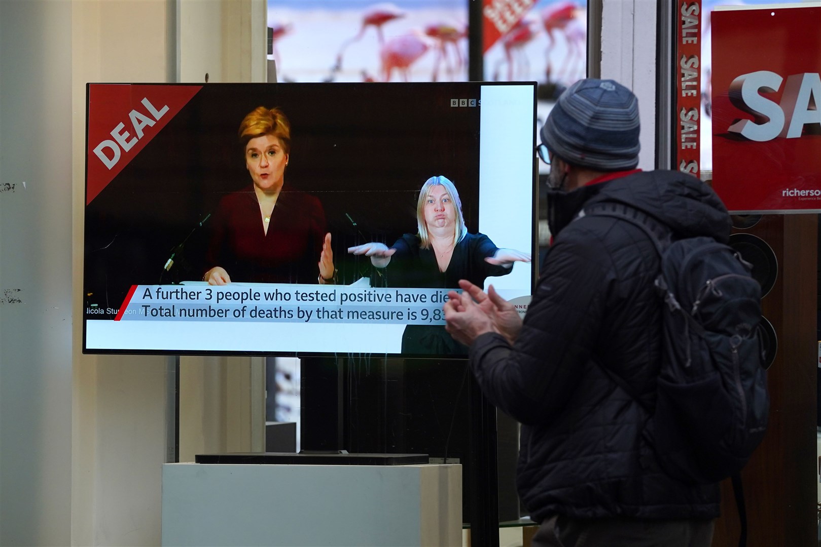 People pass a TV shop as the First Minister made a Covid-19 statement during a virtual sitting of the Scottish Parliament (Andrew Milligan/PA)