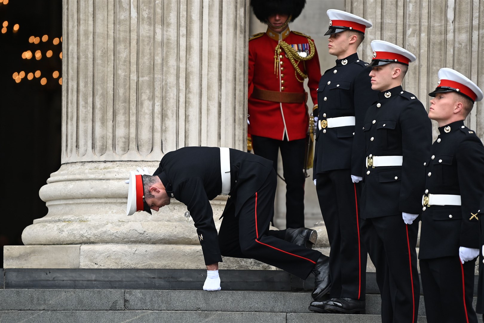 A member of the military stumbles on the steps of St Paul’s (Daniel Leal/PA)