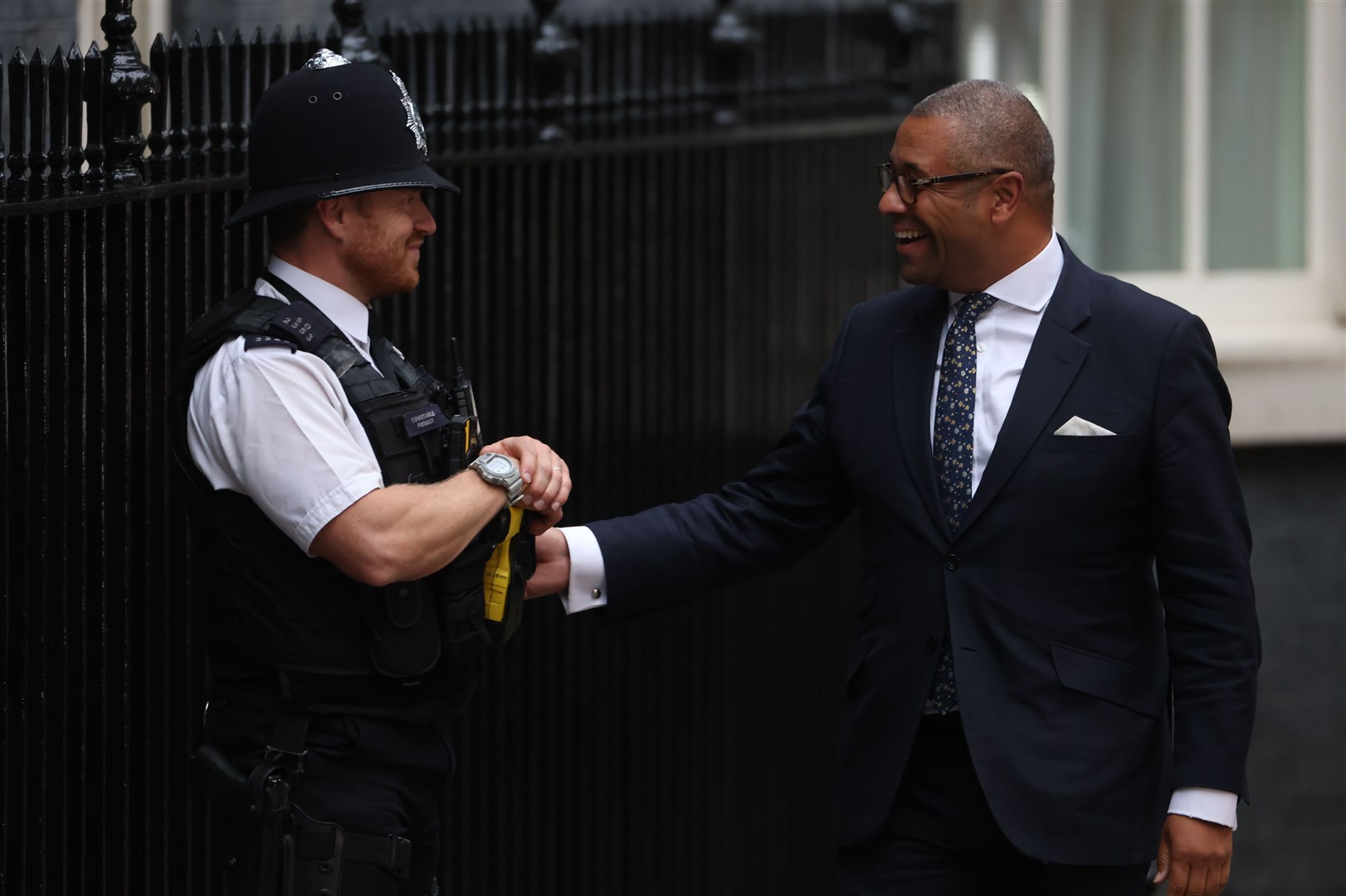 James Cleverly greets a police officer as he arrives for a meeting with Prime Minister Liz Truss at Downing Street (James Manning/PA)