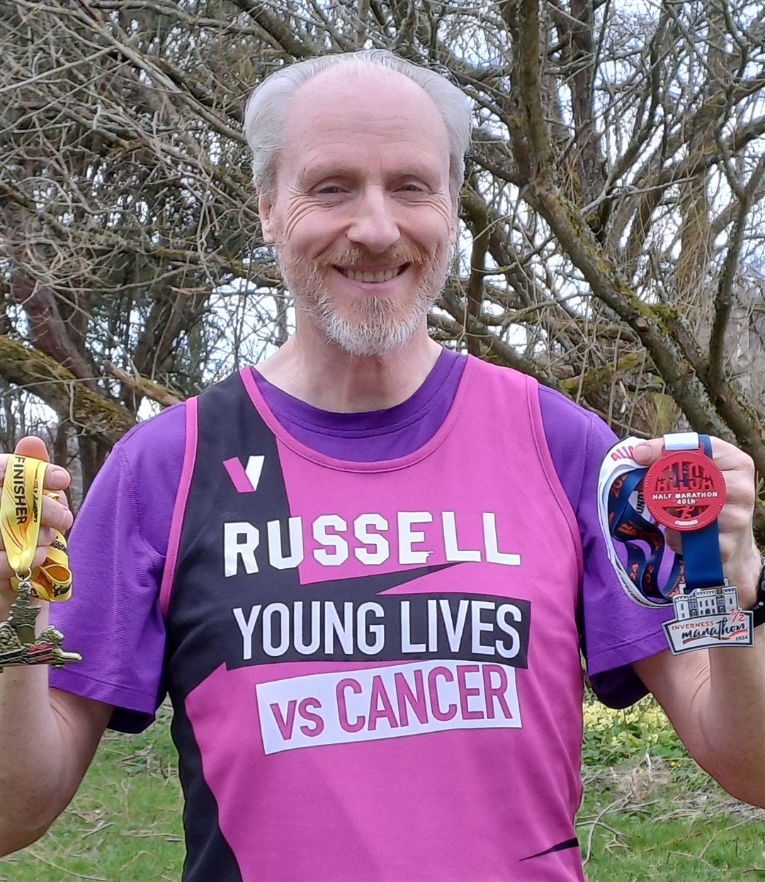 Russell shows off his latest haul of medals. He is running for a cause close to his heart.