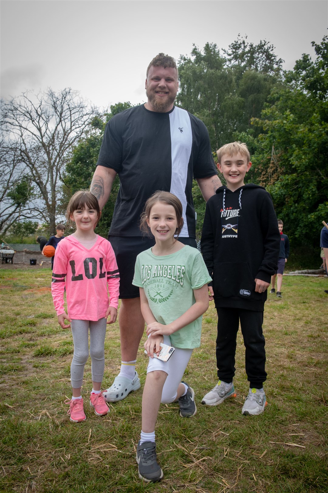 Elsie Matheson, Freya Dalgetty and Talan Matheson with the worlds strongest man Tom Stoltman. Picture: Callum Mackay..