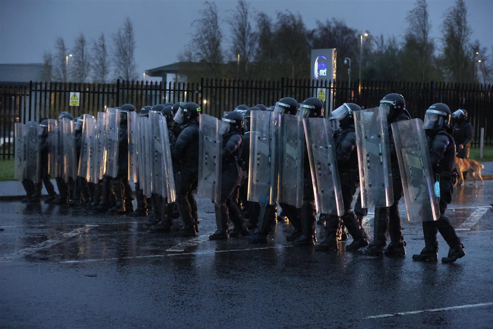 PSNI officers with riot shields line the Springfield road (Liam McBurney/PA)