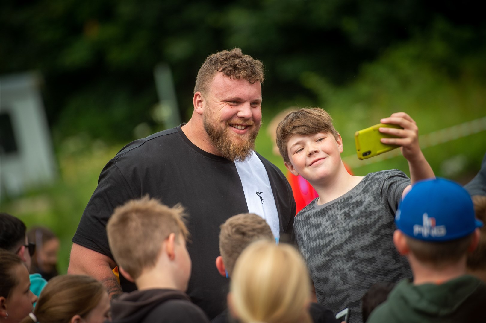 Harry Urquhart with quick selfie with the worlds strongest man Tom Stoltman. Picture: Callum Mackay..