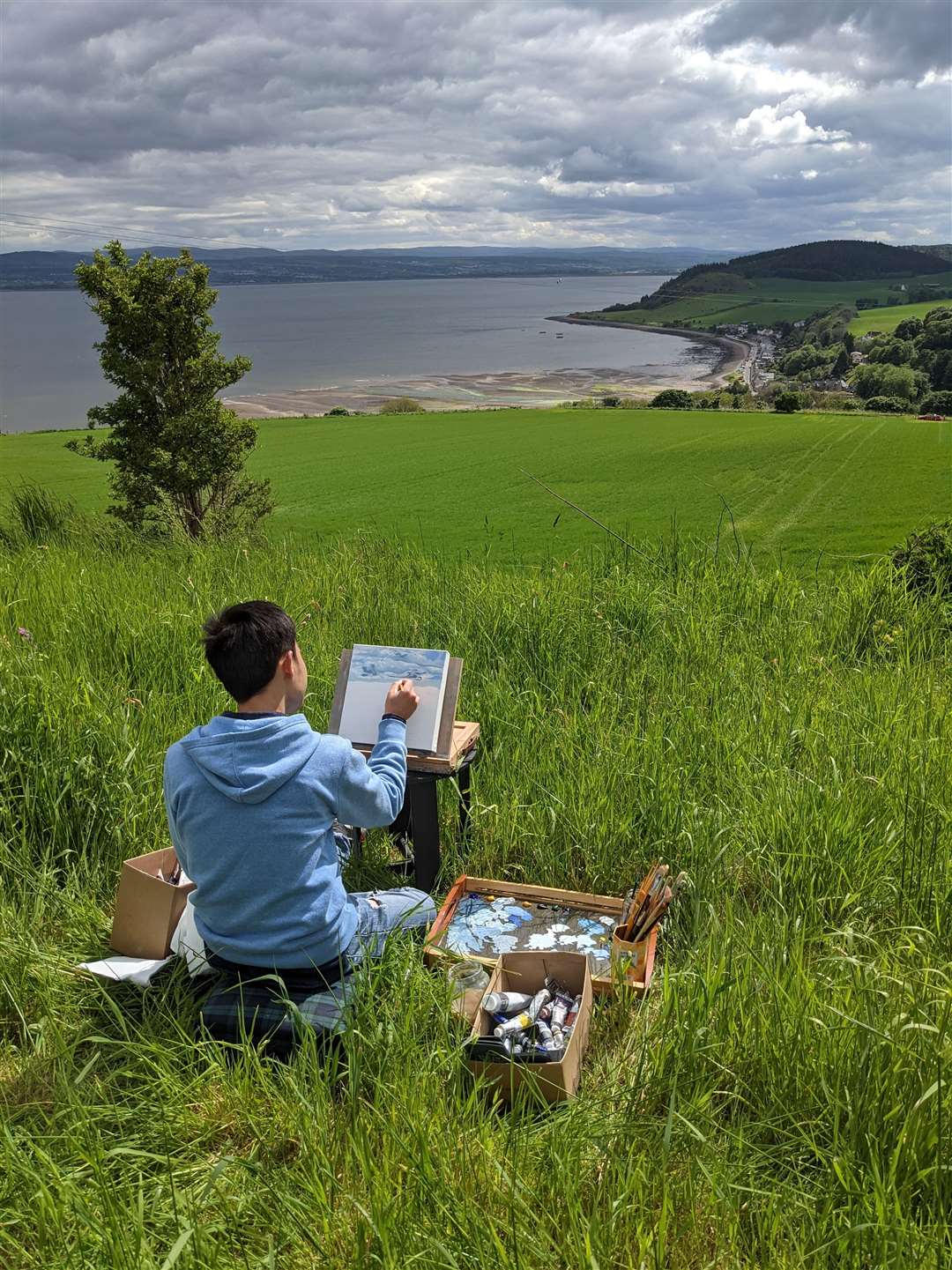 Tuan Nguyen paints a landscape near his home on the Black Isle.