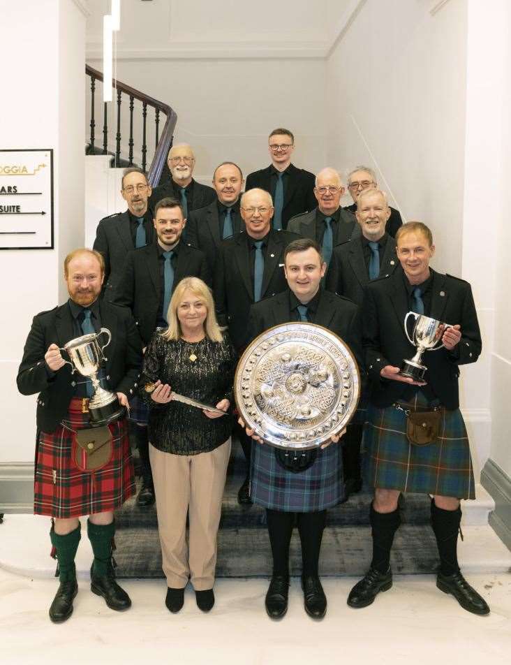 Nina MacKellor with the male voices along with their trophy haul - Mull and Iona shield (overall winners of male voice); Hector Russell dirk for conductor of the winning choir; Glen Ballachulish trophy for highest marks in Gaelic; Welsh trophy Cor Meibion Bro Glndwr for highest marks in music, plus a Sangobeg Investments Ltd cash prize.