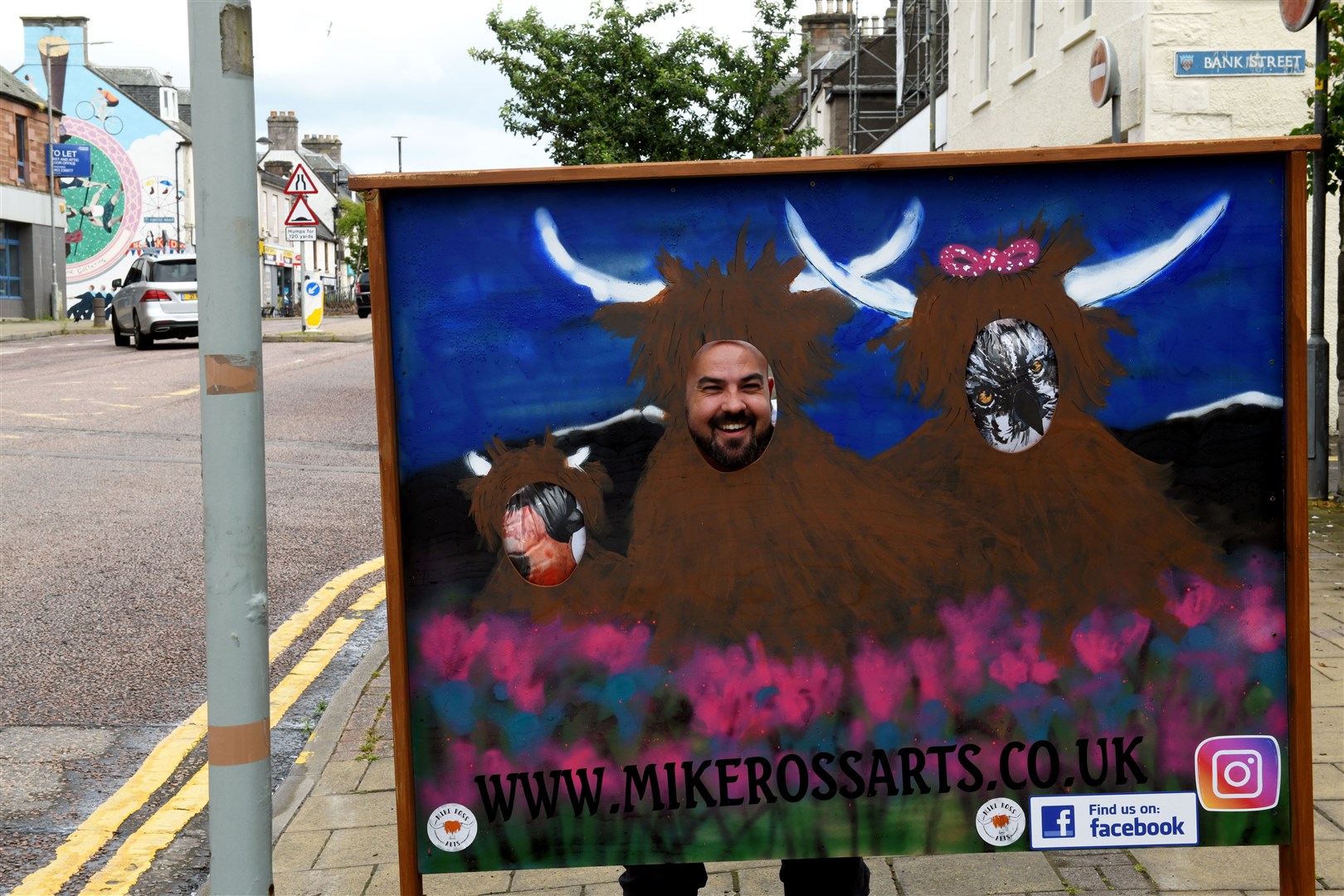 Mike Ross with his head in the new sign outside his shop. Picture: James Mackenzie..
