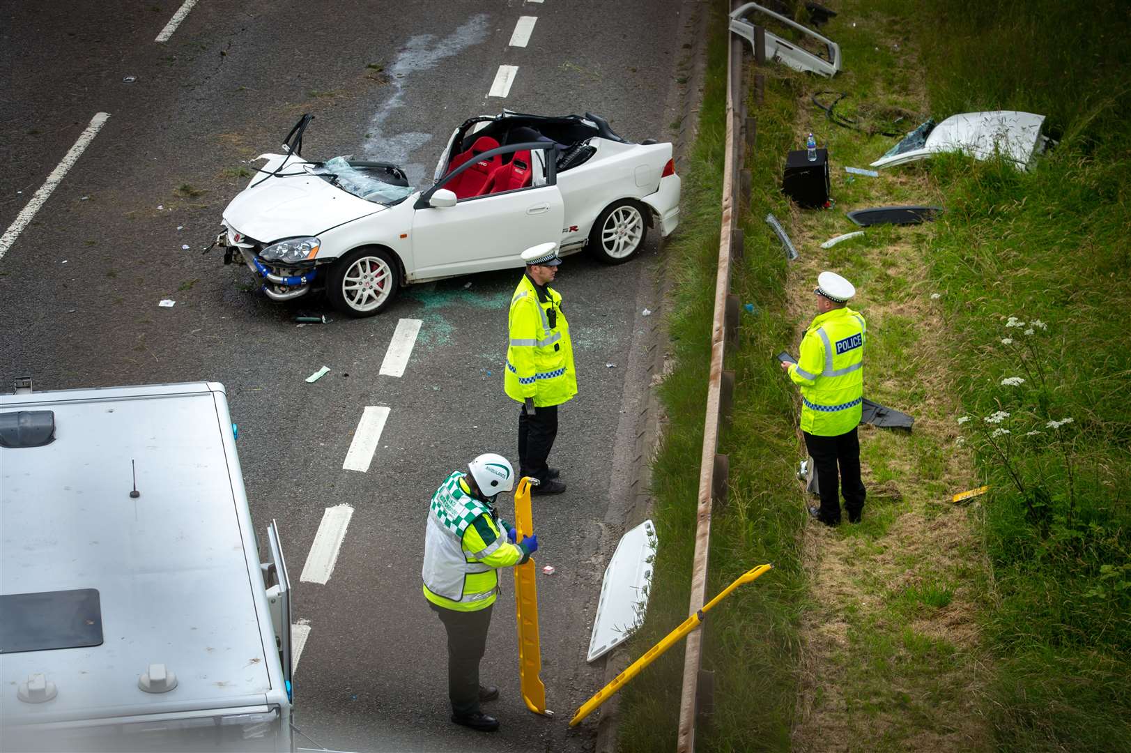 Police officers investigating the scene of the car crash on the A9 yesterday afternoon (July 13).