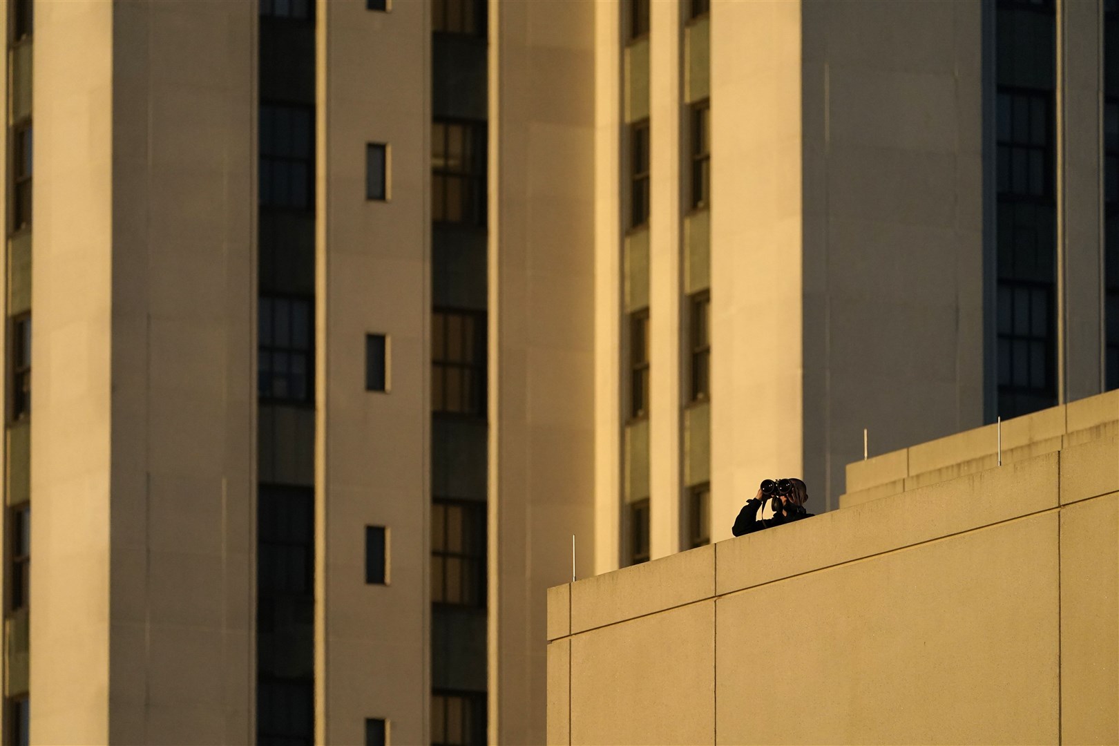 A member of the security team watches from a roof before President Donald Trump arrives at Walter Reed National Military Medical Centre (Jacquelyn Martin/AP)