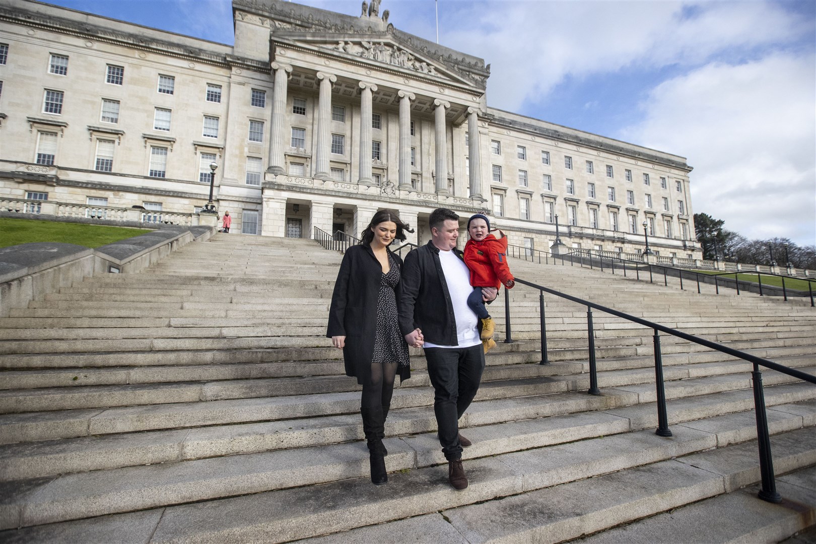 Daithi MacGabhann with his mother and father on the steps of Parliament Buildings at Stormont (Liam McBurney/PA)