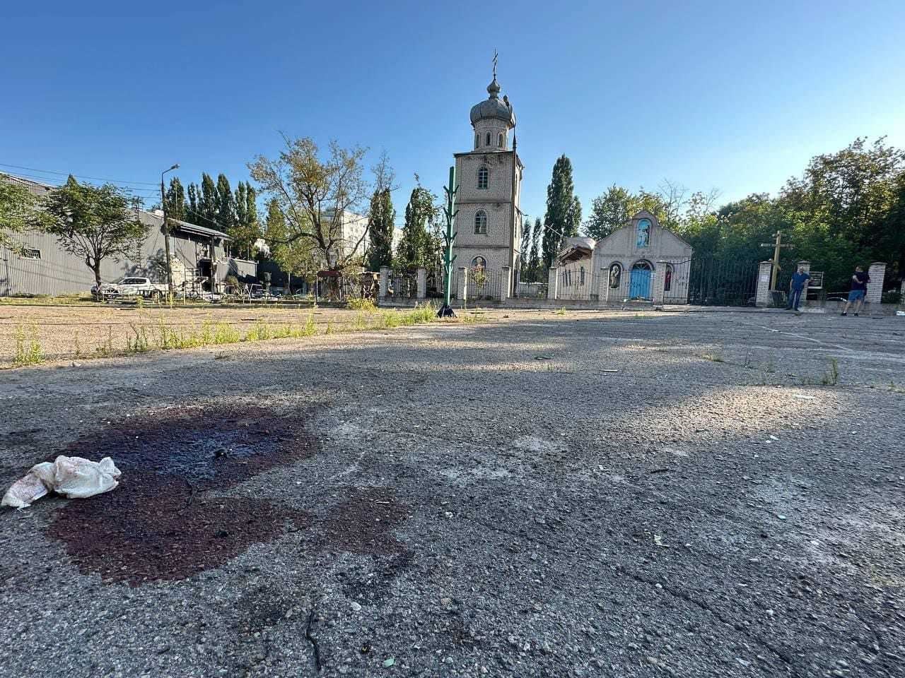 Blood stains the ground in front of buildings bombed out by Russian attacks.