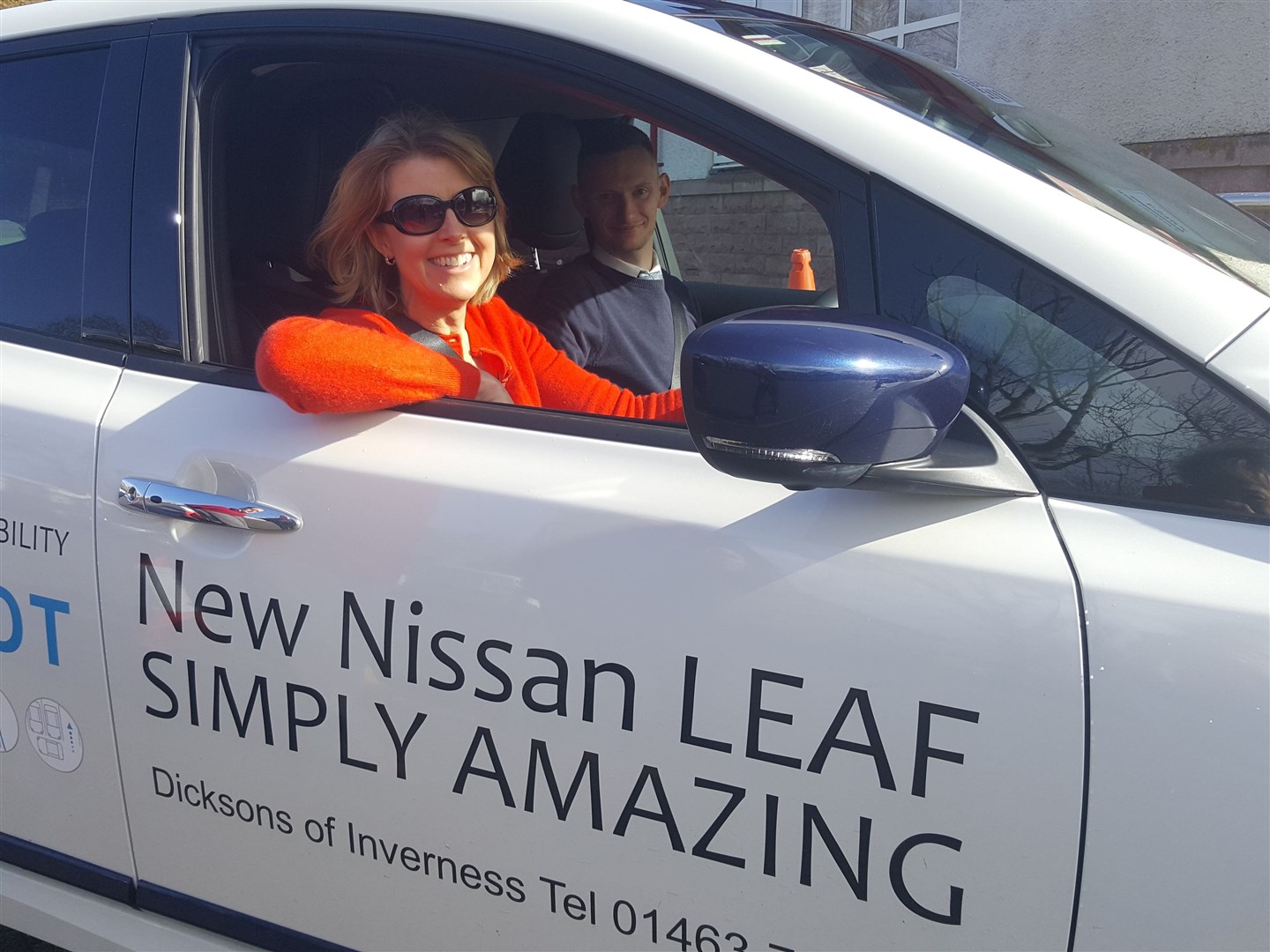Ullapool resident Cathy Higginson at the wheel of the Nissan Leaf, accompanied by Kyle Fitzgerald of Dicksons of Inverness at the Let's Go Electric e-vehicle day in Ullapool