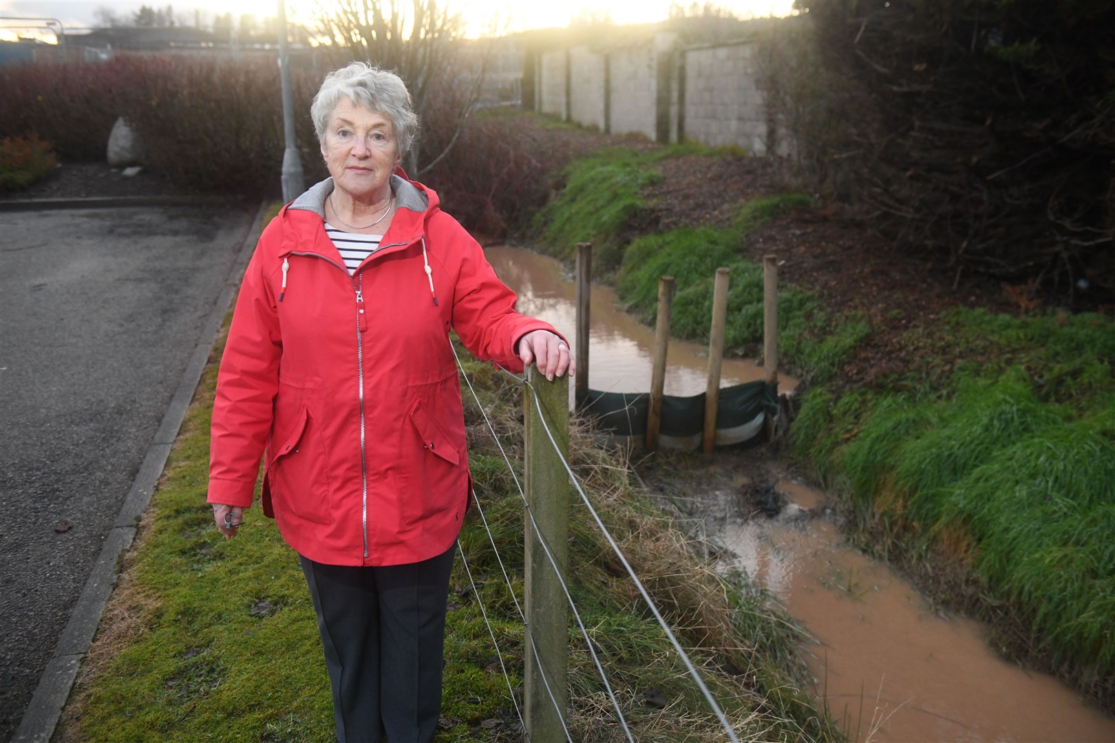 Alison Taylor, local resident, standing next to one of the silt collectors that earlier this year wasn't, wasn't catching the silt from the work site. Picture: James Mackenzie.