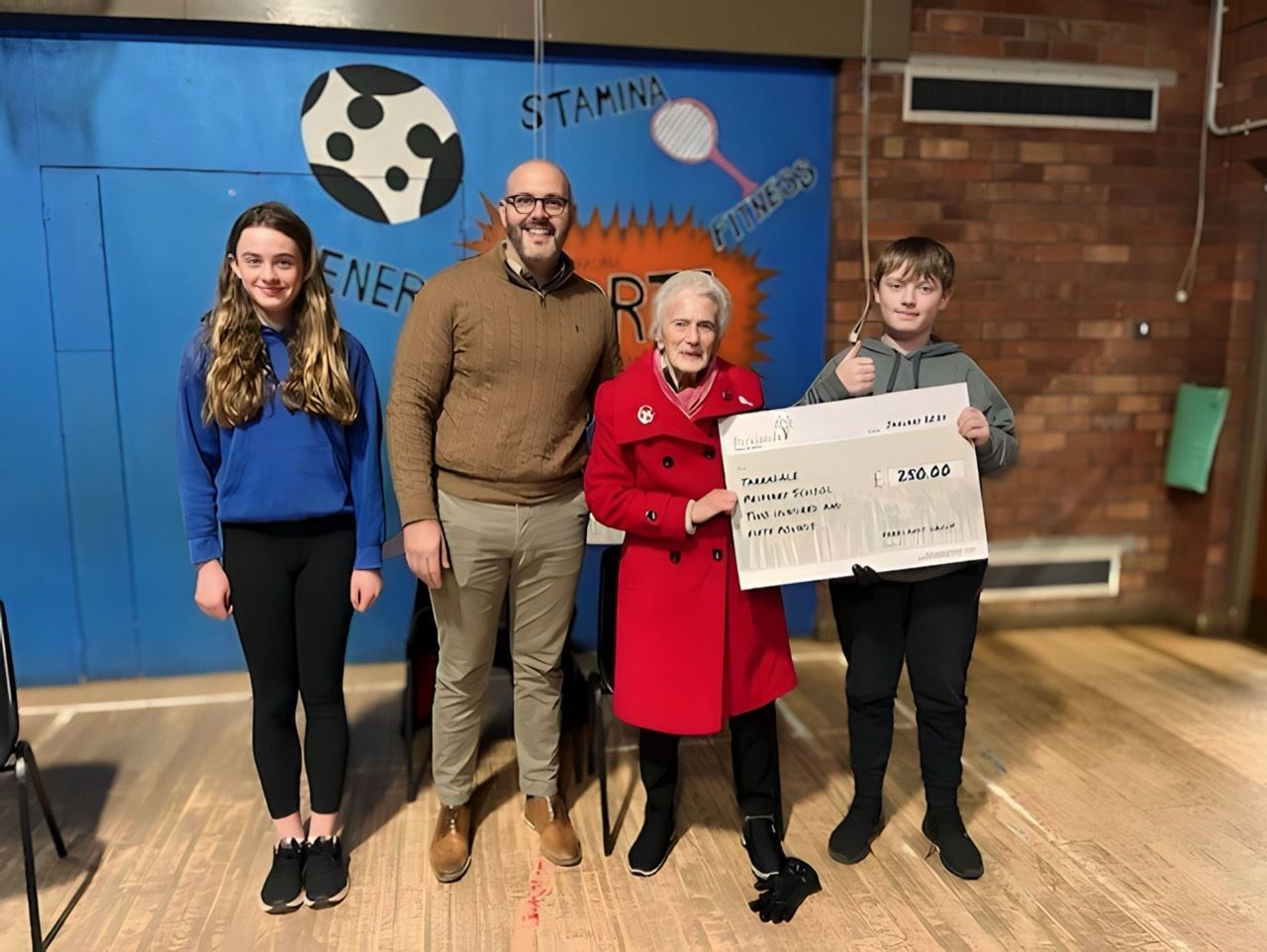Joe Greiner, manager of Urray House, and resident Ina Macfadyen present a cheque to Tarradale Primary pupils Kaitlin and Lachlan. Picture courtesy of Parklands.