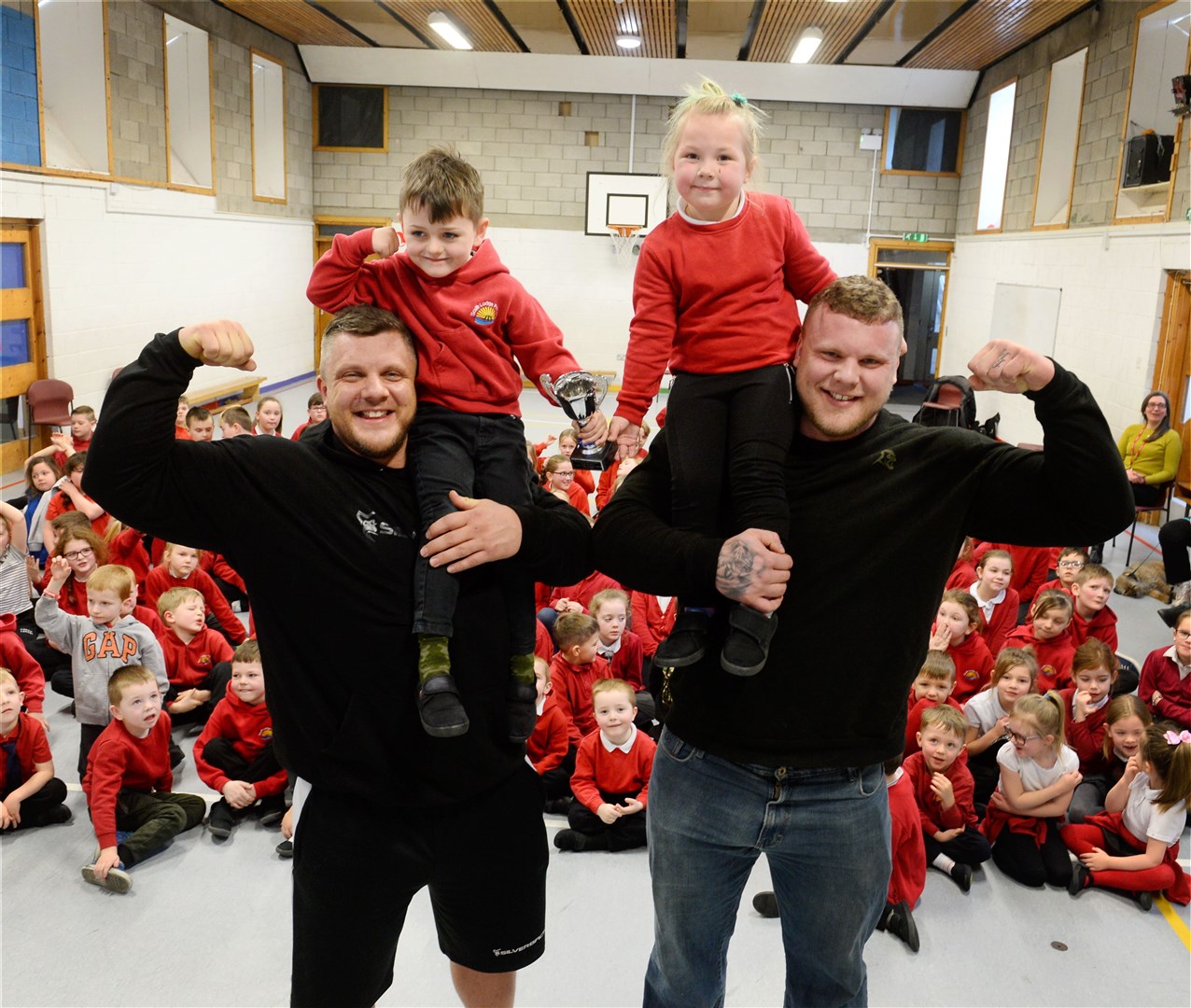 Strongman brothers Luke and Tom Stoltman during a visit to South Lodge Primary in Invergordon for a talk to the pupils.P1 pupils Leighton Williamson and Alise Goba with Luke (left) and Tom. Picture: Gary Anthony.