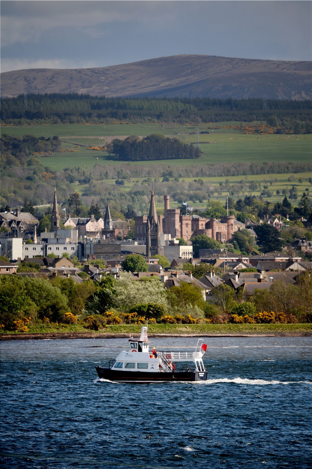 The Dolphin Spirit boat sails through the waters of the Beauly Firth, with Inverness in the background. Picture: Gair Fraser.
