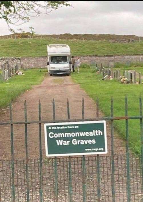 A motorhome parked in a graveyard.
