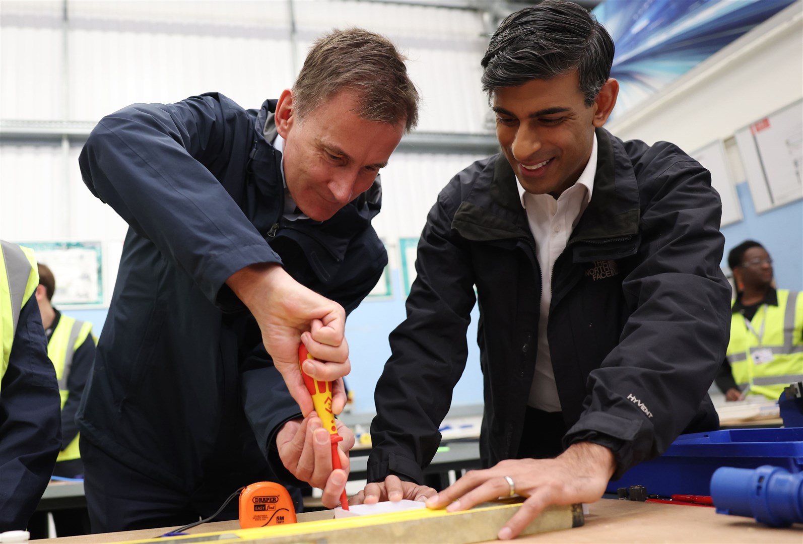 Prime Minister Rishi Sunak and Chancellor Jeremy Hunt help out with some electrical work during a visit to the Enfield Centre in north London (Daniel Leal/PA)