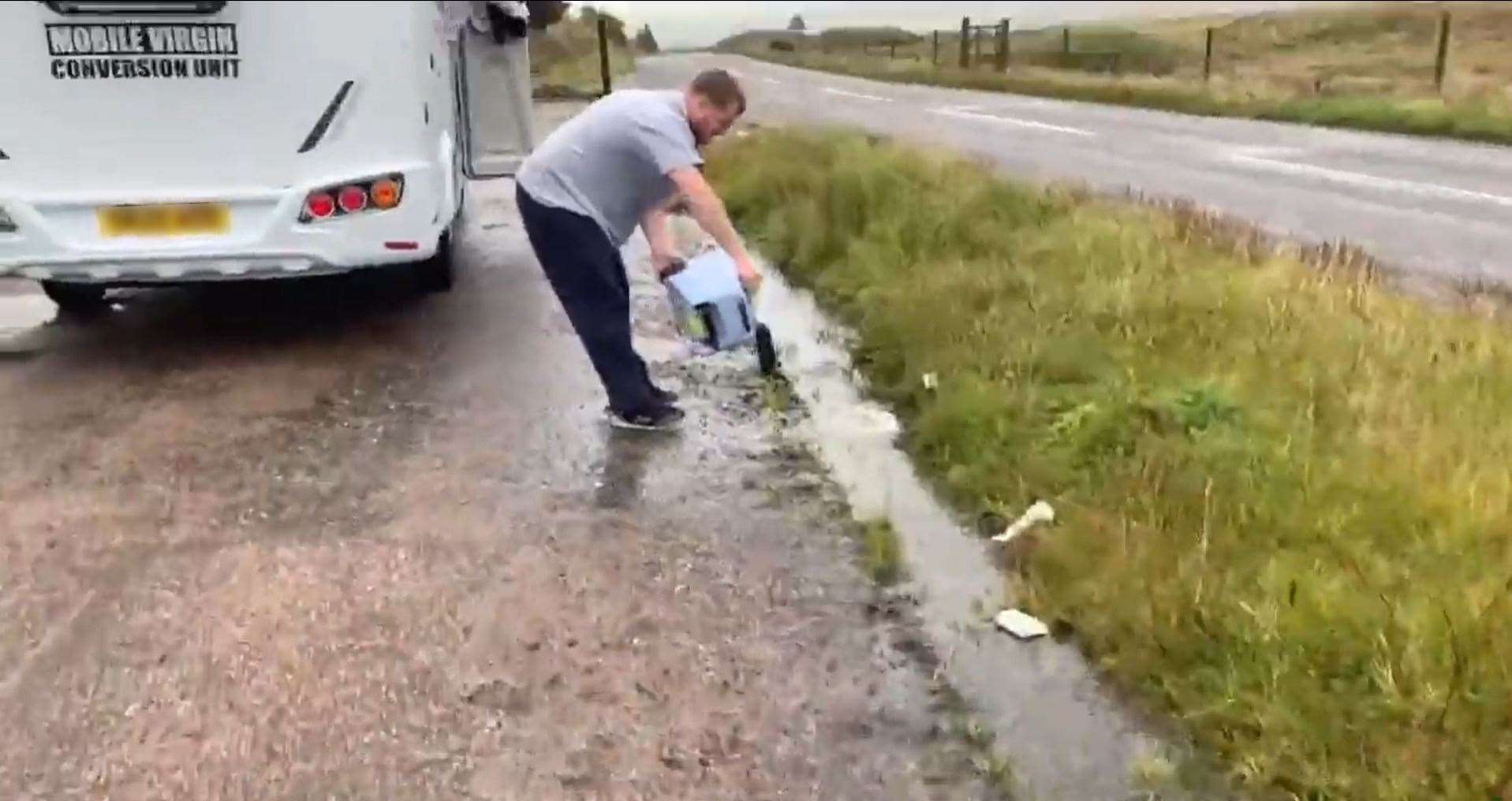 A still from a video showing a man emptying his campervan's toilet into a layby.