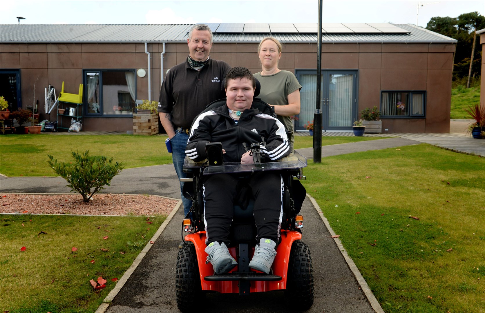 Dylan Bogue in his brand new wheelchair, pictured with his dad, Mark and his step mum, Correen McAlinden. Picture: James Mackenzie