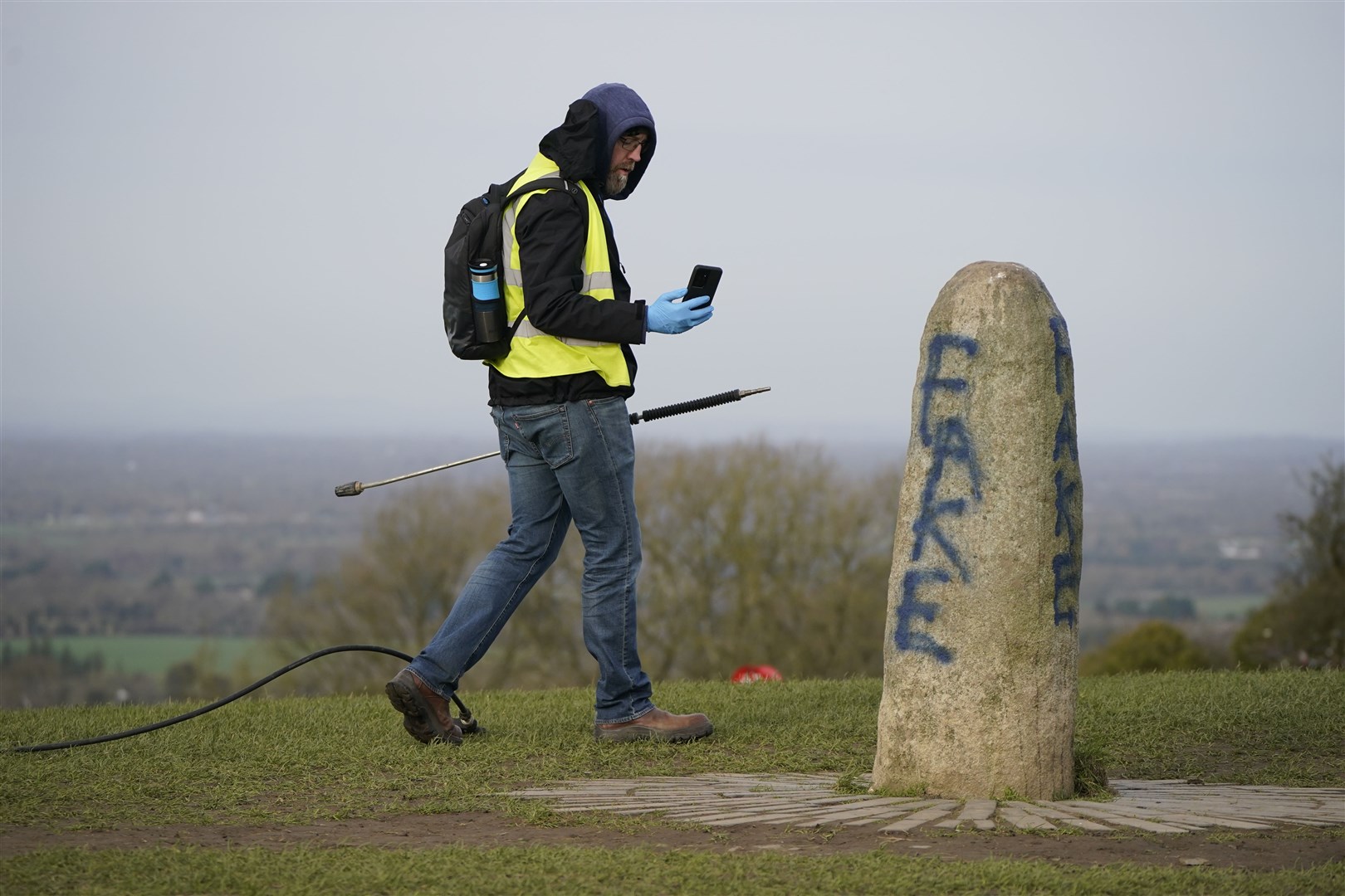 A worker from the office of public works films the graffiti on the Lia Fail standing stone (Niall Carson/PA)