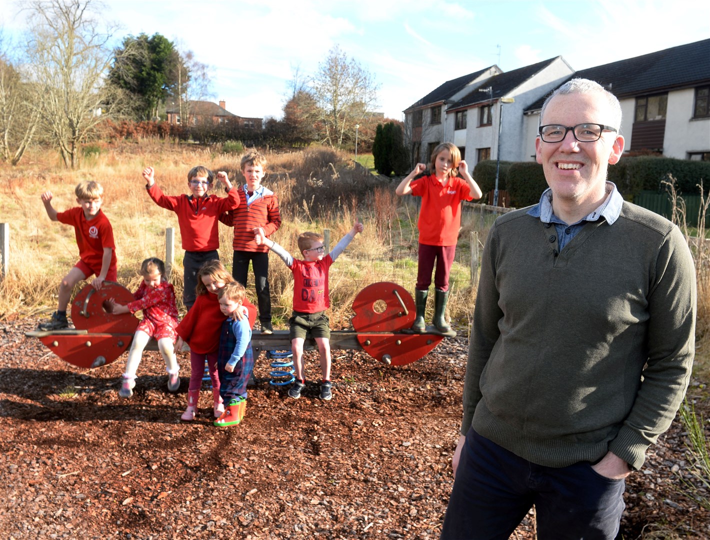 Chairman of Strathpeffer Residents' Association David Genney celebrates with local children. Picture: Gary Anthony