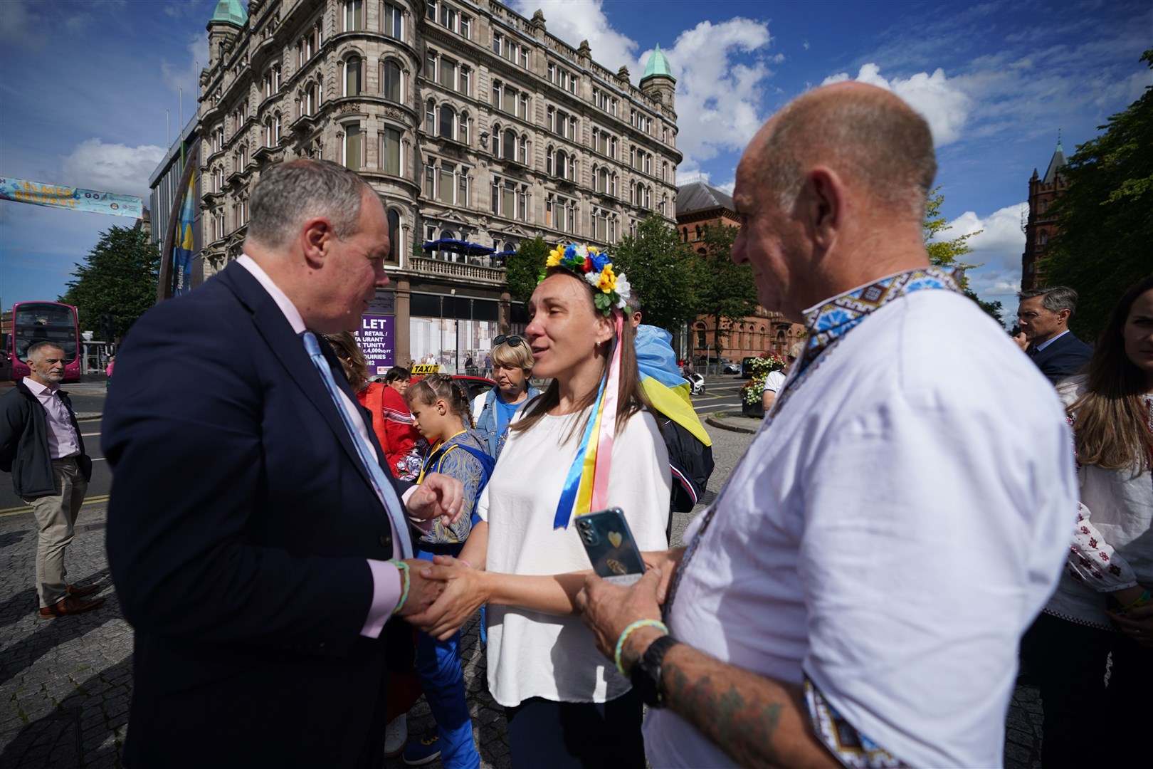 Conor Burns (left), Minister of State for Northern Ireland speaks with Inna Shynkevich from Ternopil, as he joins Ukrainians celebrating Ukraine independence Day, outside Belfast City Hall (Niall Carson/PA)