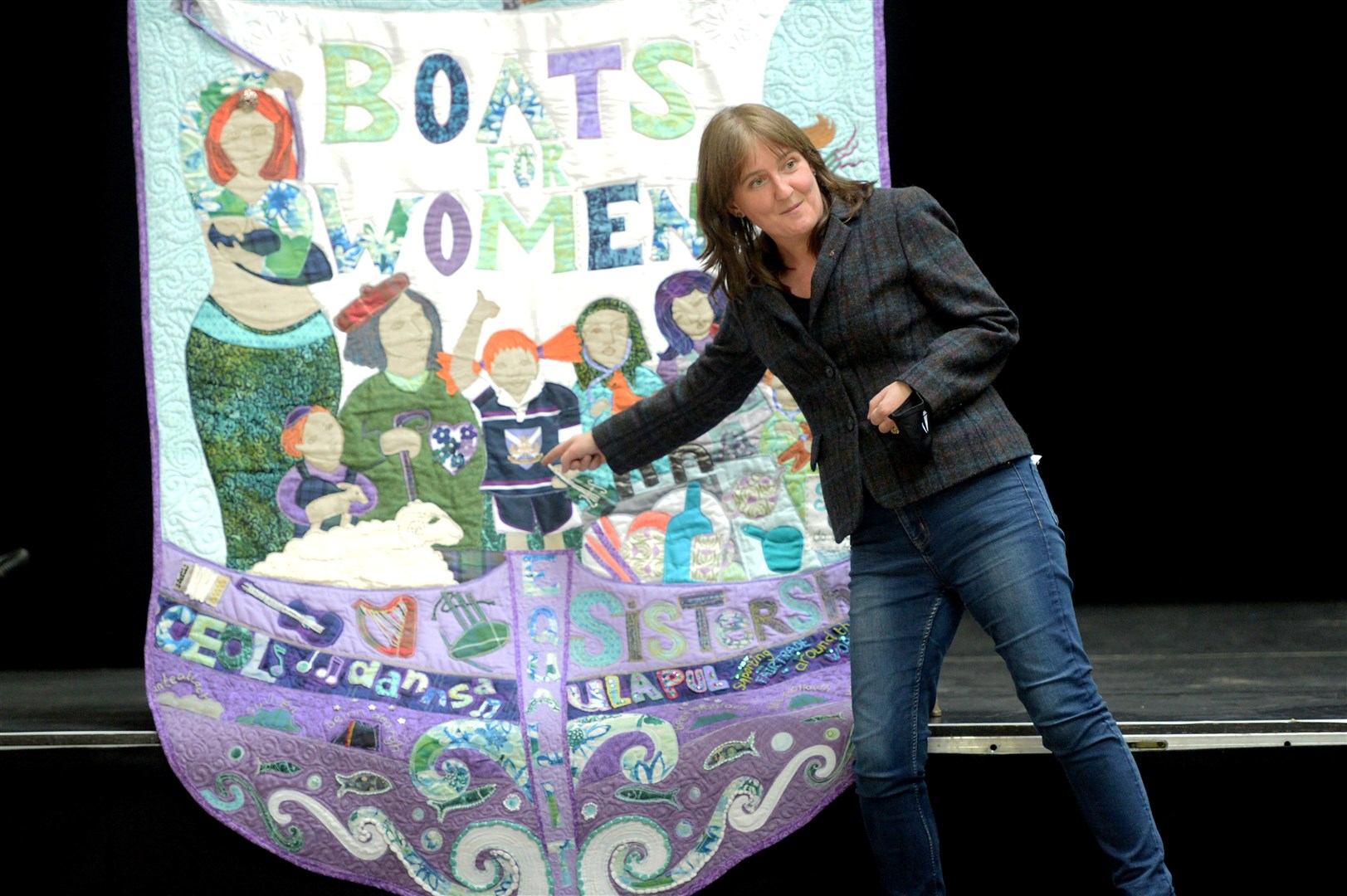 Maree Todd MSP points out the cut-up rugby shirt given to the Katie Morag character on the Boats for Women banner. Picture: James Mackenzie