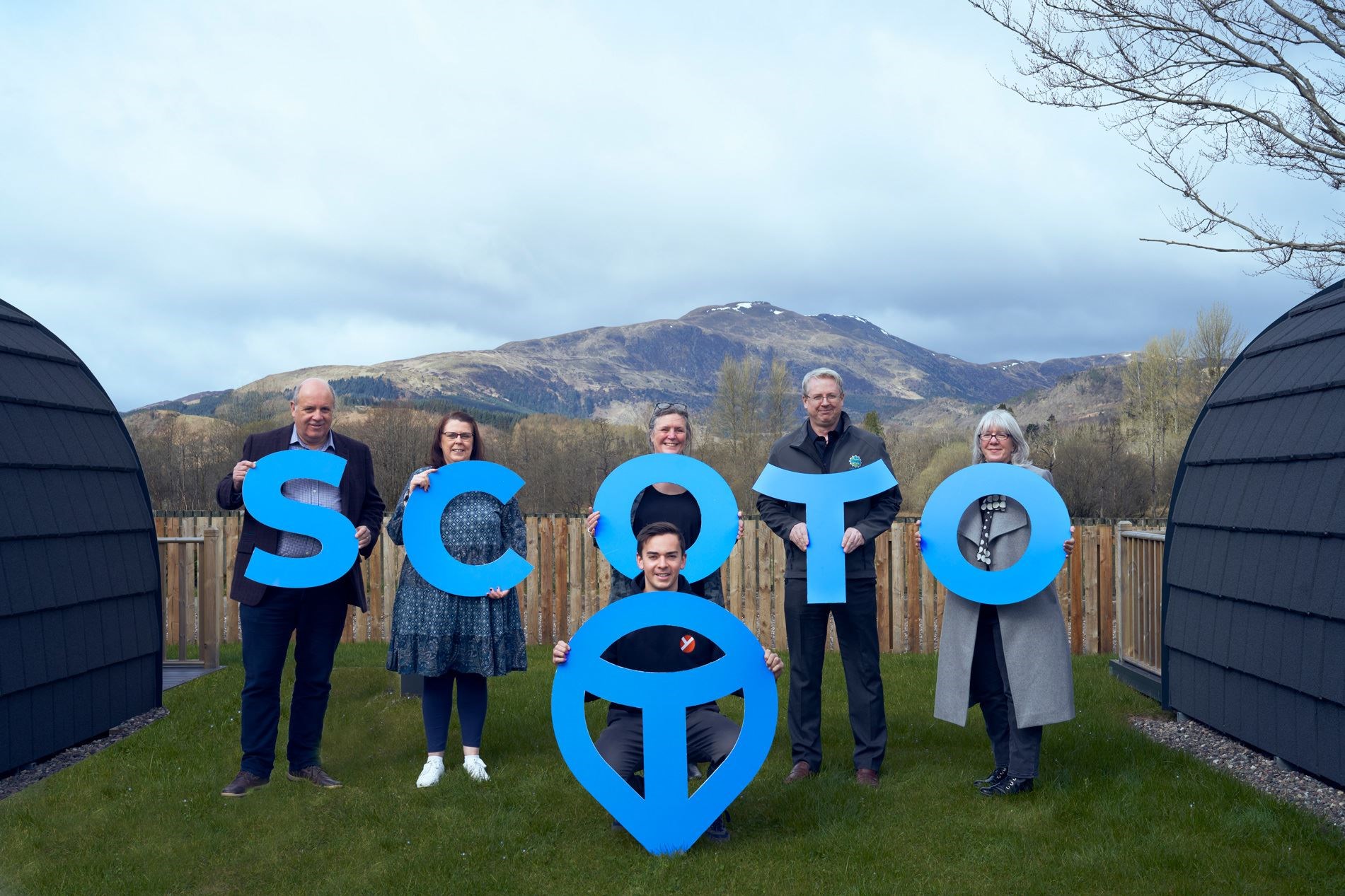 Marc Crothall (from left), CEO of Scottish Tourism Alliance | Patricia Kent, Manager at SCOTO member Callander Youth Project Trust | Carron Tobin, SCOTO Facilitator | Russell Fraser, SCOTO Chair | Diane Smith, SCOTO Coordinator | Front, Jack Wardrop, former Modern Apprentice and now Youth Worker with Callander Youth Project Trust with the SCOTO place-marker