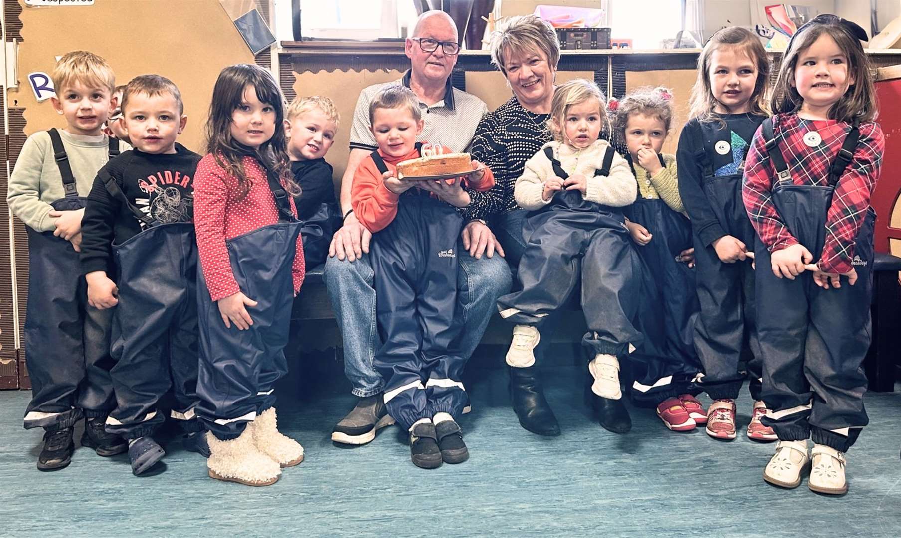 David and Eileen Mackay, with the children from Muir of Ord ELC in their new puddle suits.