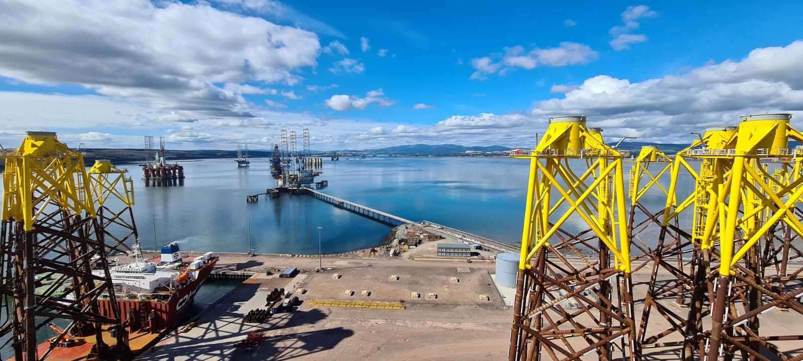 Moray East foundations being unloaded for temporary storage at Nigg Energy Park in 2020 with Cromarty Firth in the background.