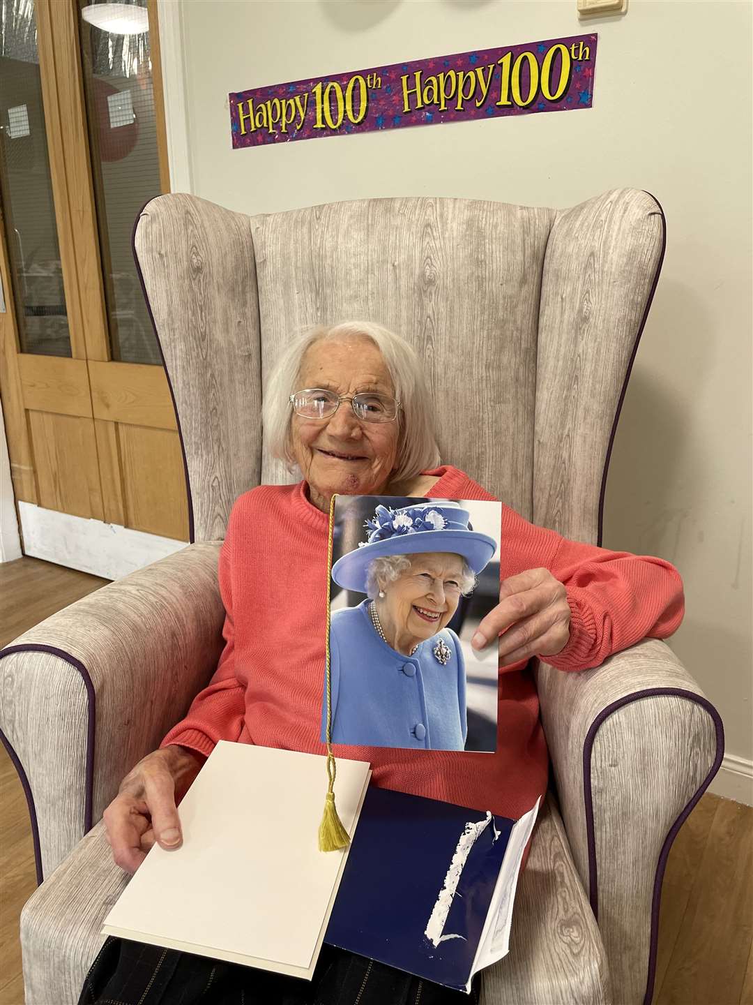 Elizabeth McMillan opening a birthday card from The Queen to mark her 100th birthday