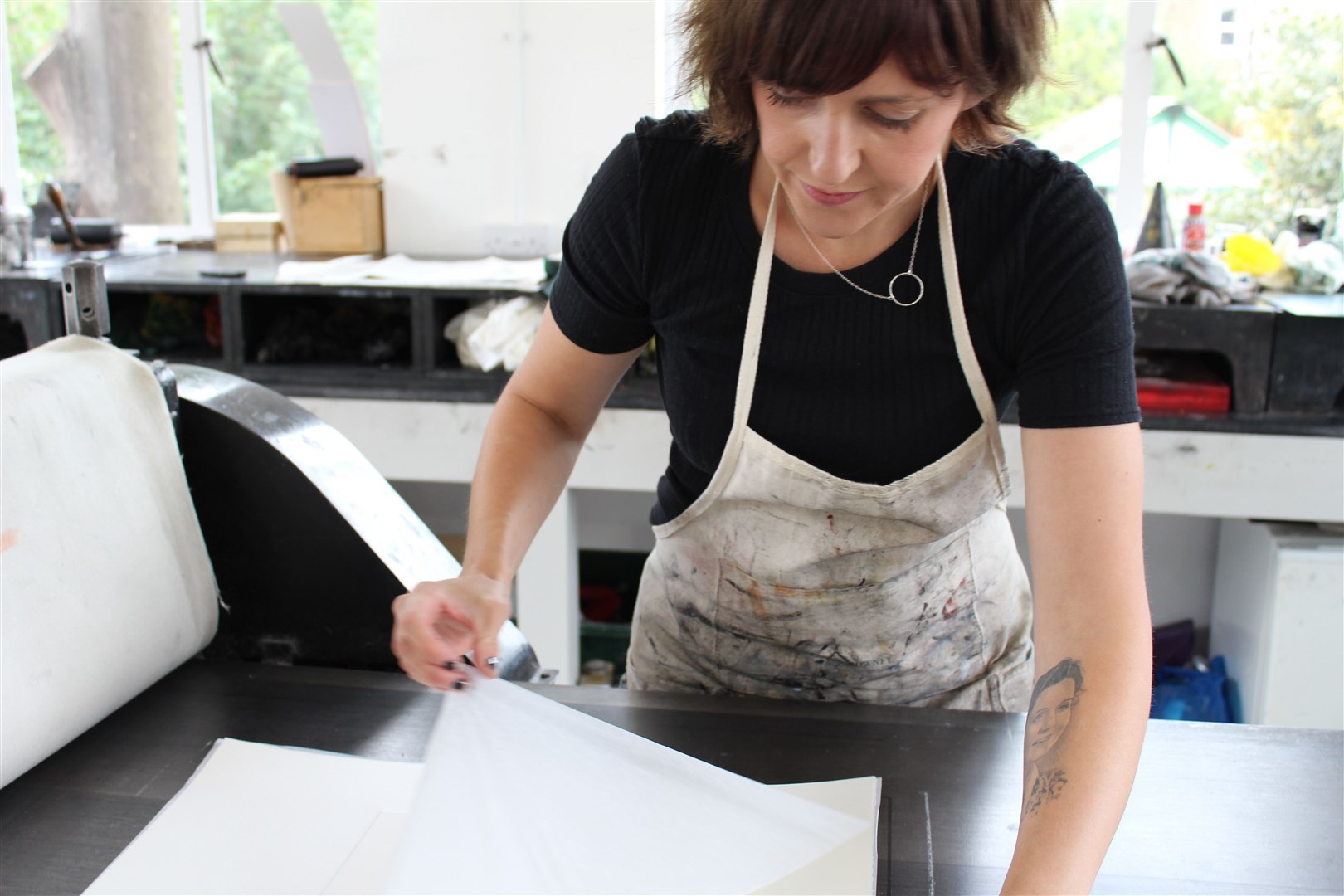 Artist Fiona Stewart, who is featured in the Press Gang exhibition, at the etching press.