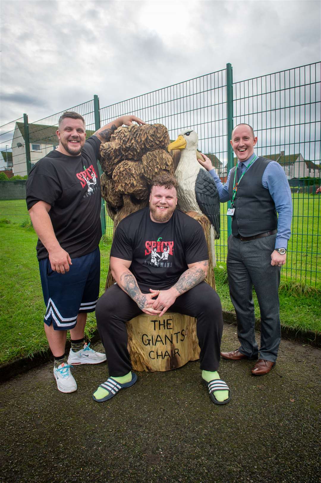 Tom and Luke Stoltman were surprised by schoolchildren at South Lodge with a specially made Giants Chair Bench thanks to a donation they made to the school.  They are pictured with director David Hayes-MacLeod.  Photo: Callum Mackay