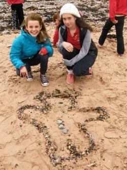 Cromarty schoolchildren turn beach debris into sand art during their eco day.