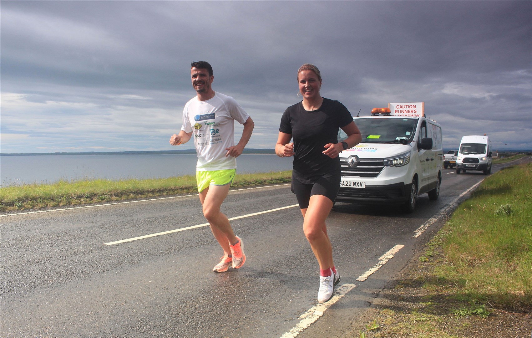 Steven Mackay and Seana Forbes running between Wick and John O'Groats on Sunday, with the support vehicle close behind. Picture: Alan Hendry