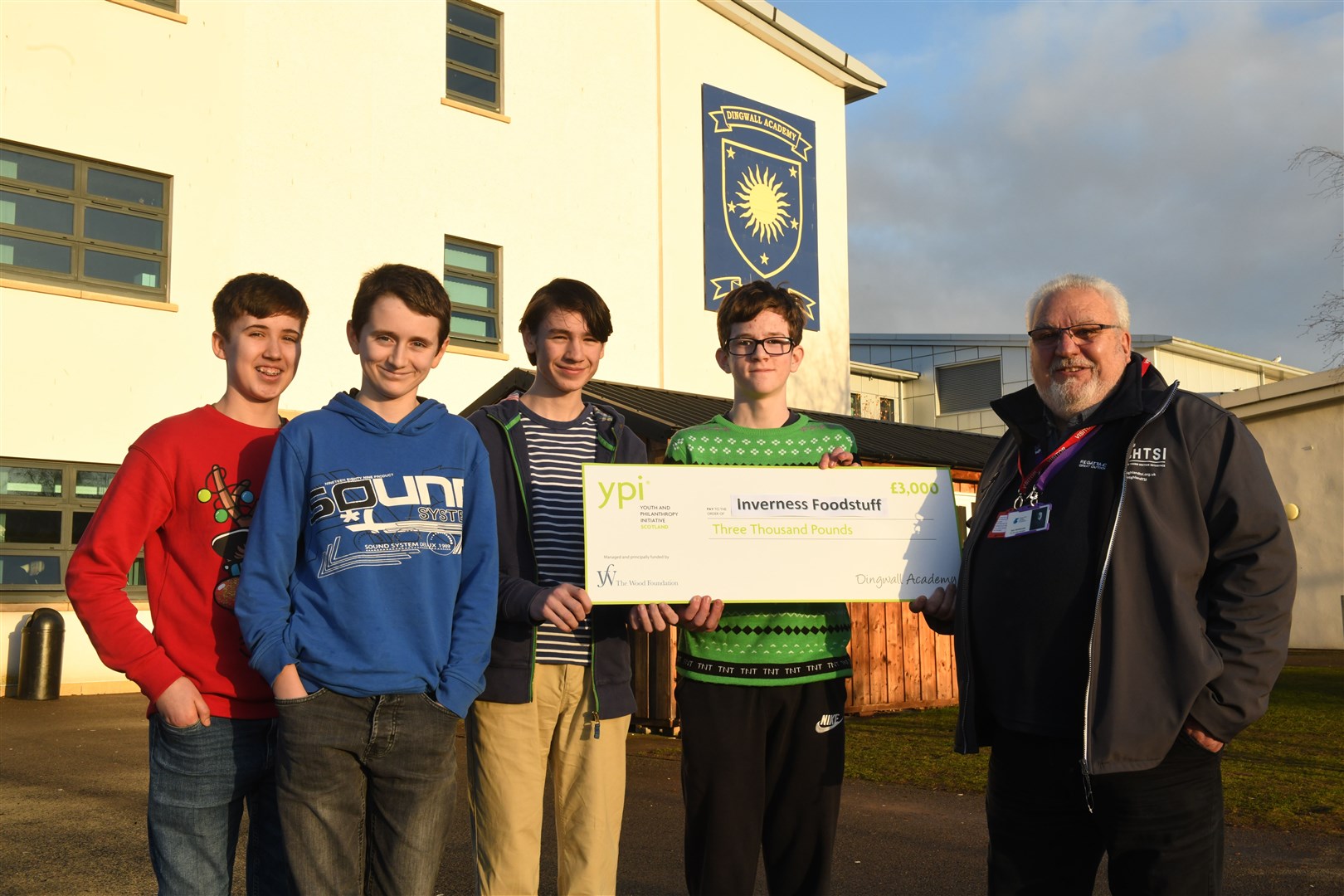 Dingwall Academy S3 pupils Harry Stewart, Seth Hitchen, Magnus Atkinson and Angus Porter hand over their winnings to Iain McKenzie, vice chairman of Inverness Foodstuff. Picture: James Mackenzie.