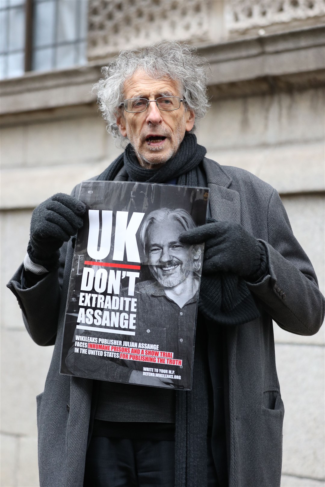 Piers Corbyn holds up a poster in support of Julian Assange outside the Old Bailey, London (Yui Mok/PA)