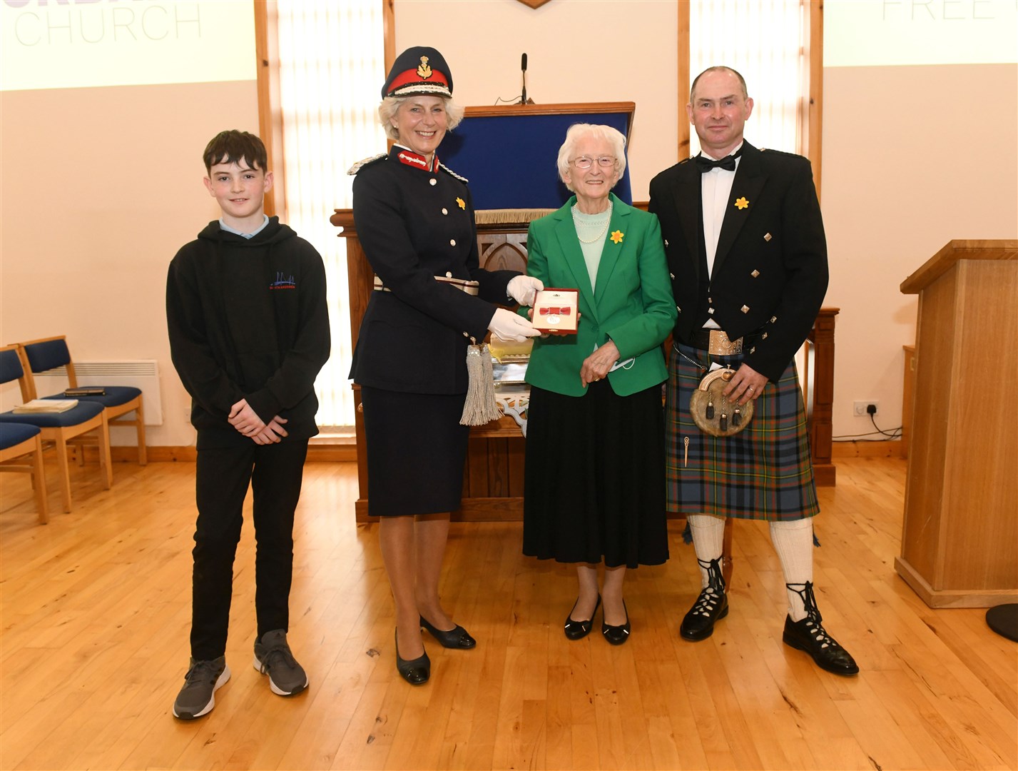 Joanie Whiteford (Lord Lieutenant of Ross and Cromarty) presents Davina Gillies with the BEM, also in the picture grandson Calum Gillies (left) and son Ruairidh Gillies.