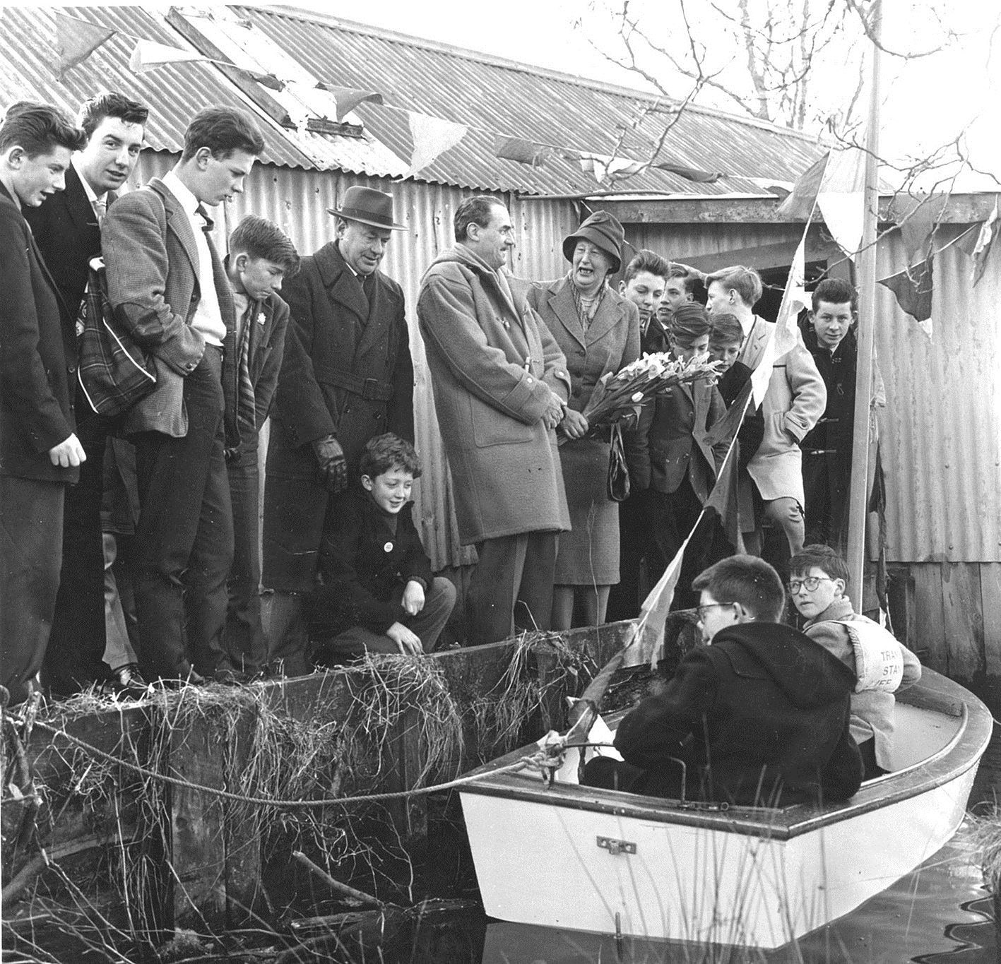 Onlookers having good fun at the launch of the Mallard, the product of the boat-building class, with Lady Maud Baillie doing the honours.