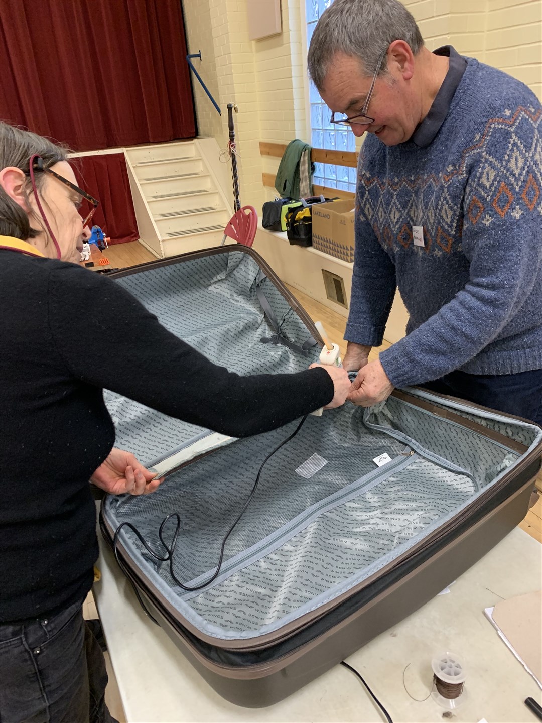 Gillian Newman and Steve Bramwell fixing a suitcase with a poignant back story attached to it.