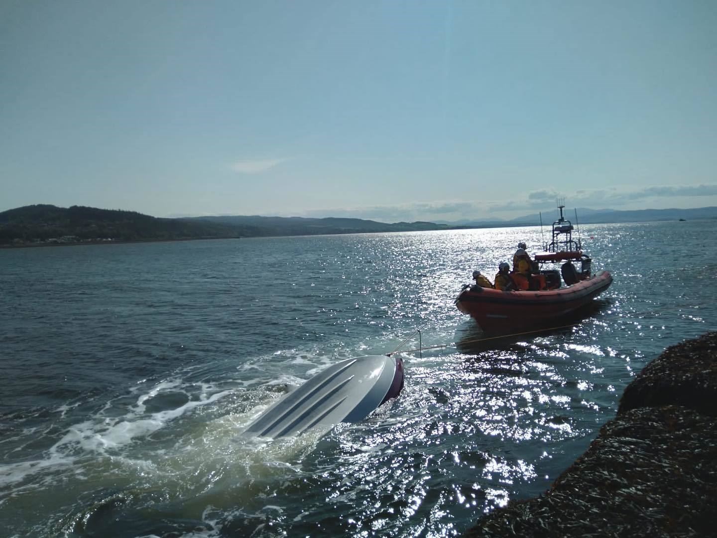 The RNLI Kessock lifeboat helps tow the capsized vessel ashore. Picture: RNLI / RNLI Kessock.