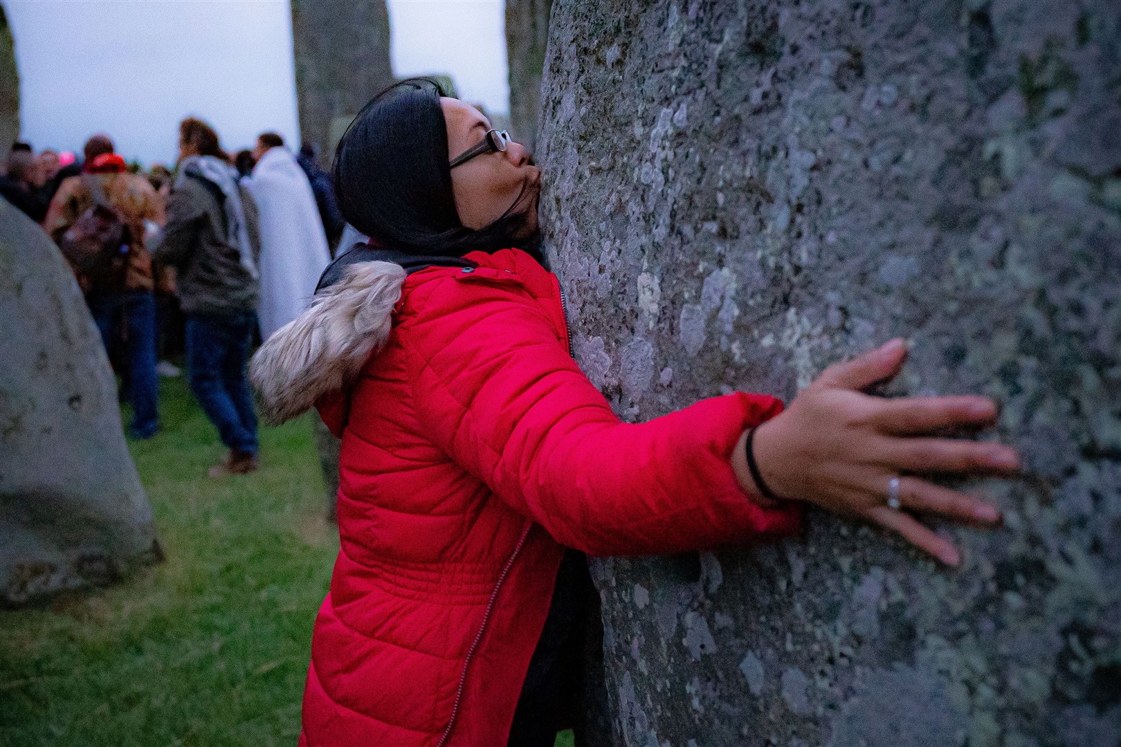 A woman kisses a stone during Summer Solstice at Stonehenge (Ben Birchall/PA)