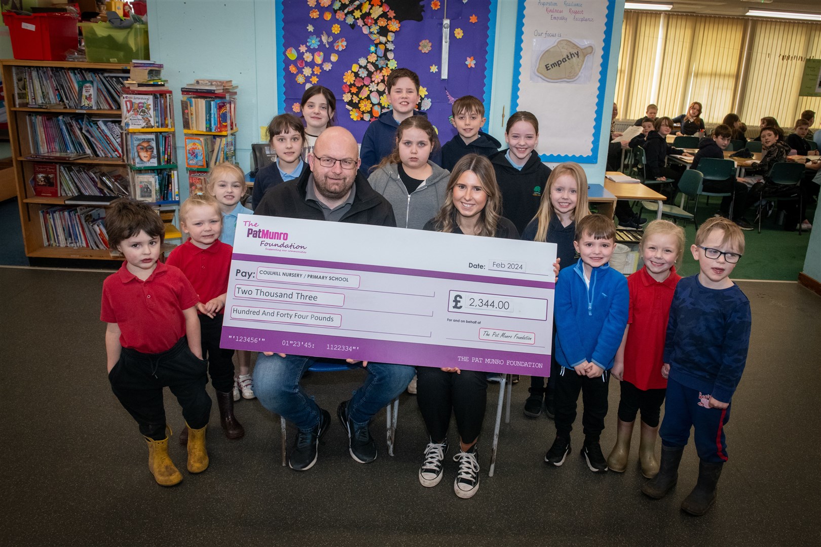 Pat Munro contribute new books/tablets to Coulhill Primary/nursery school. Pat Munro's Michael MacDonald and Orla Gilliland with pupils. Picture: Callum Mackay