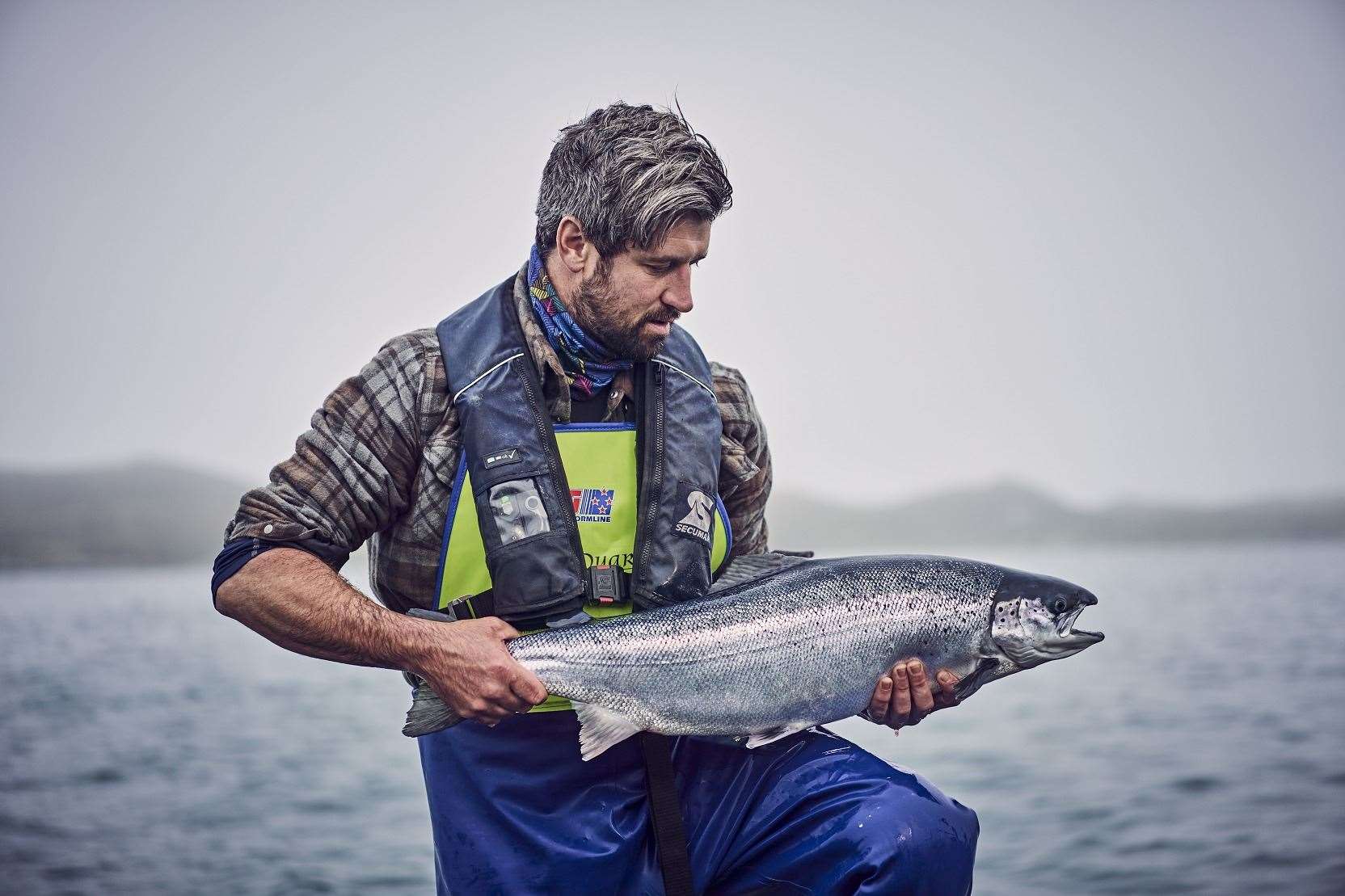 A Loch Duart husbandryman holding a salmon.