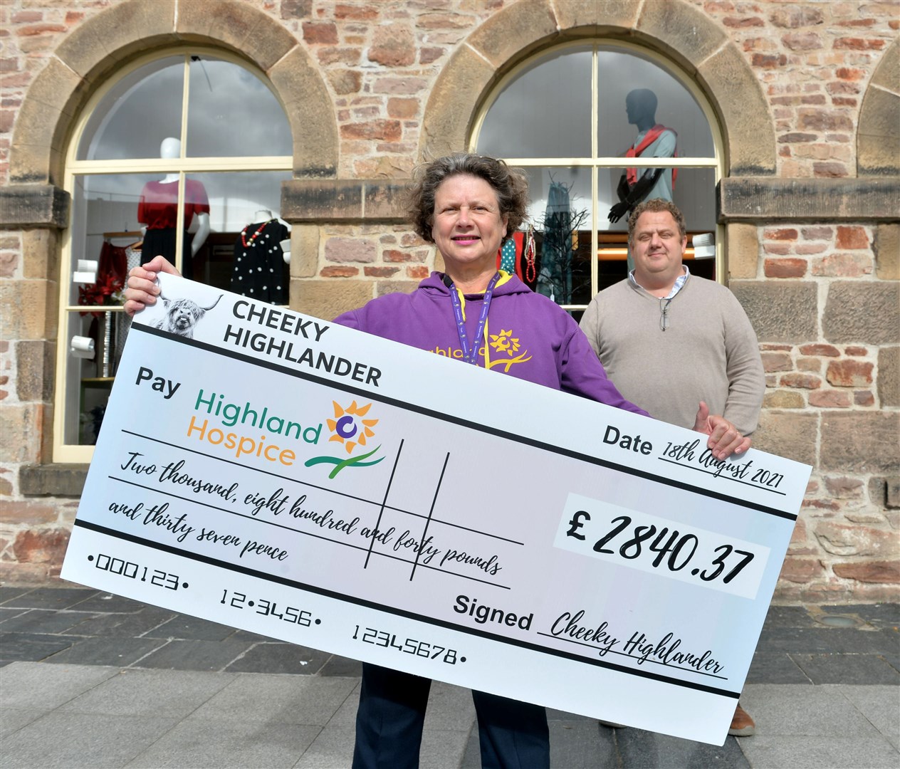 Marcus Salter of Cheeky Highlander antiques raised over £2800 for Highland Hospice with the help of a chainsaw artist.Katie Gibb accepted the cheque at the Highland Hospice shop in Falcon Square. Picture: Callum Mackay