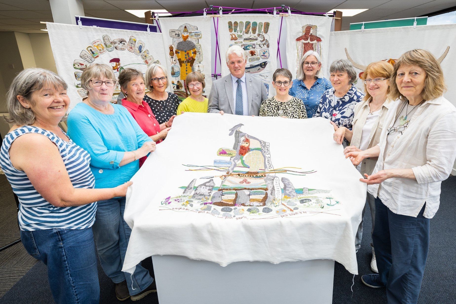 Calanais Stones tapestry panel, Isle of Lewis: Cllr Ian Brown (centre), Pictured (left to right) are regular helpers in the Inverness hub, from around Inverness, Black Isle and Dornoch: Bernadette Finnie, Kathleen Dale, Jill Barnes, Sue Gardiner, Margaret Clyne, Cllr Ian Brown, Jacqueline Smith, Alison Phimister, Kirsty Neilson, Mairi Murray, Sheena Norquay. Picture by: HLH/Paul Campbell Photography.