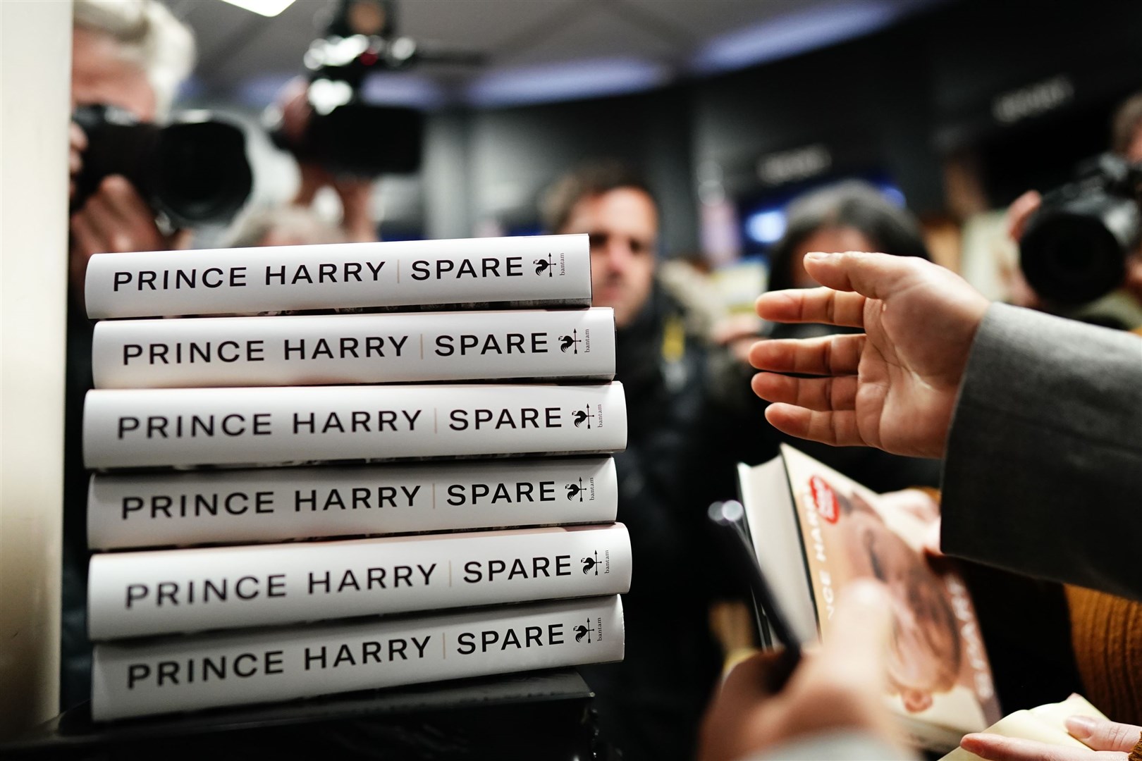 People reach for copies of of Spare, the newly released autobiography from the Duke of Sussex at WH Smiths in Victoria Station (PA)