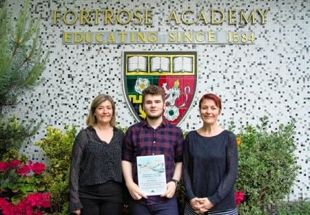 Fortrose Academy leaver Joe Inman receives the award from Caroline Hewat's daughters, Jade (left) and Corrina.